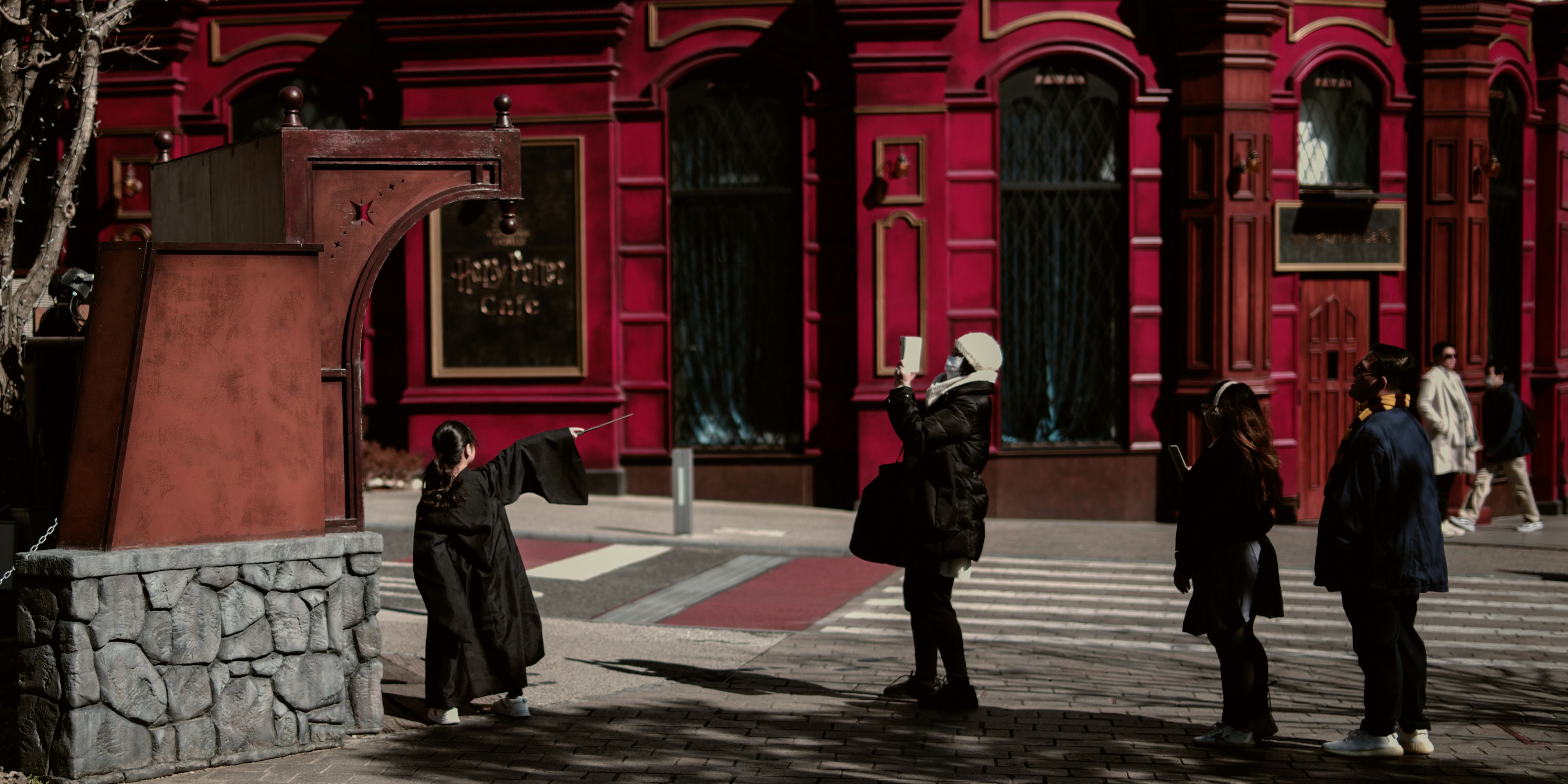 Des personnes posant devant un bâtiment rouge et une installation artistique