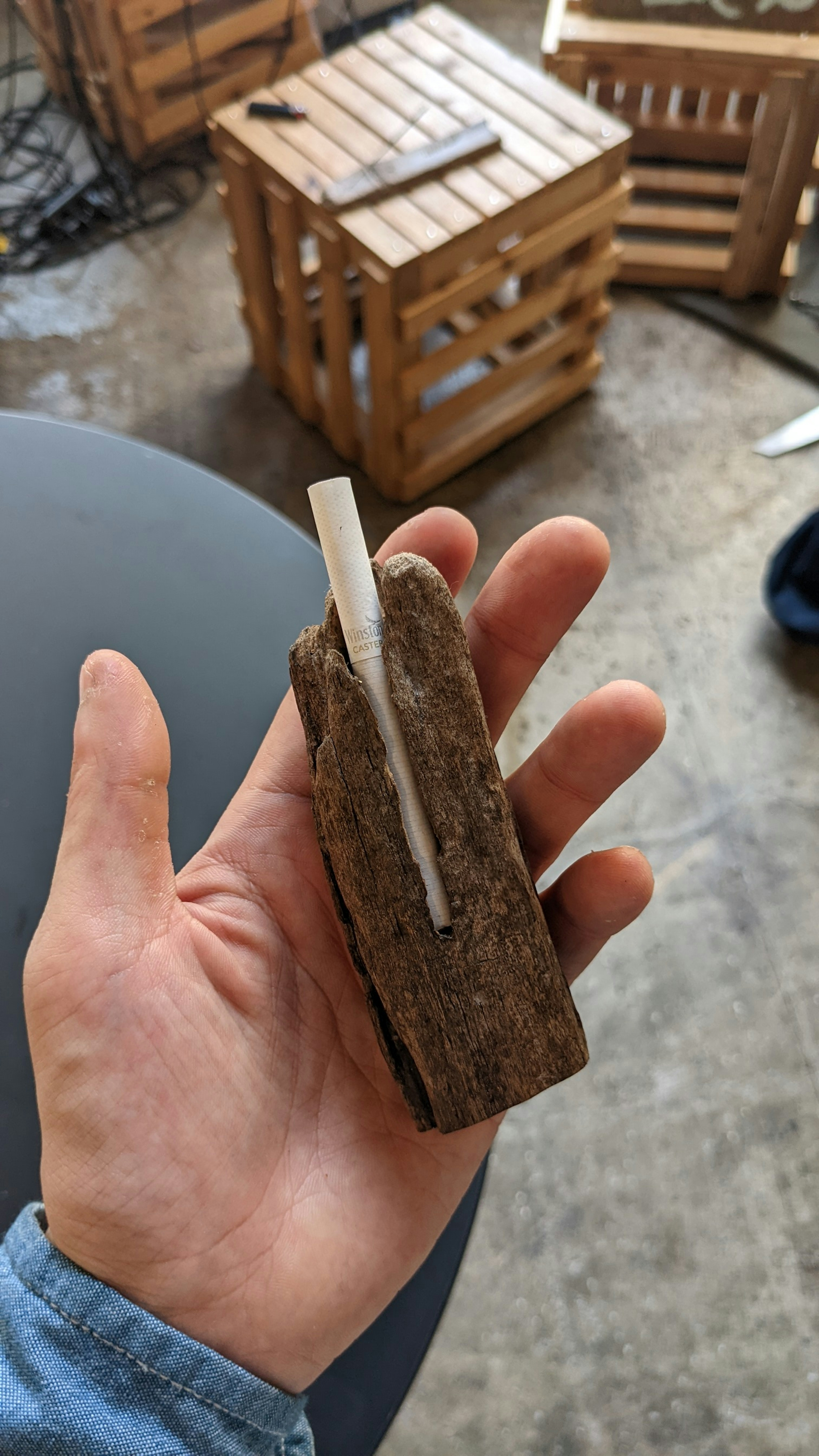 Eine Hand hält ein Stück Holz mit einem weißen Stock darauf