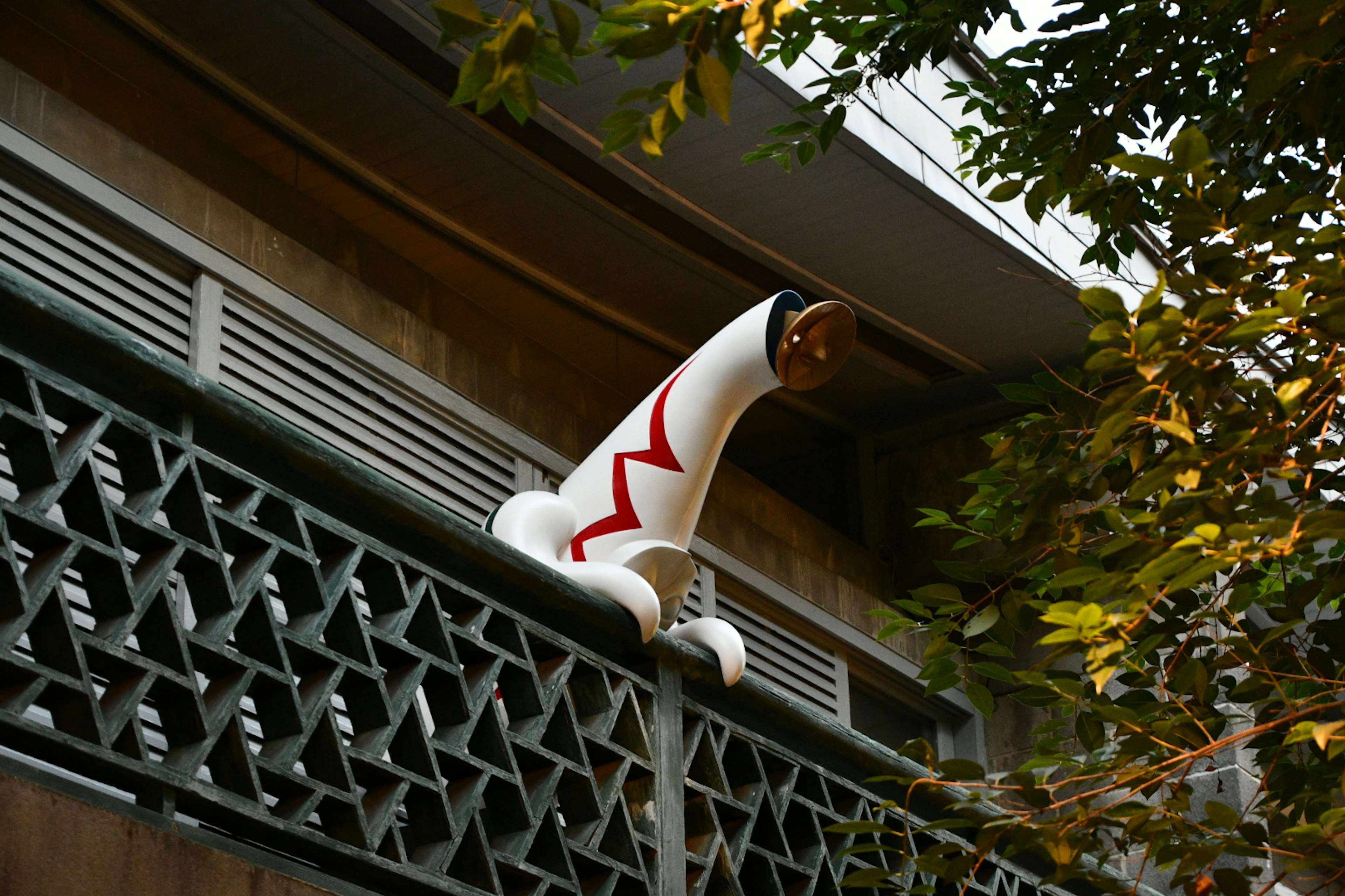 A white object with red patterns protruding from a building