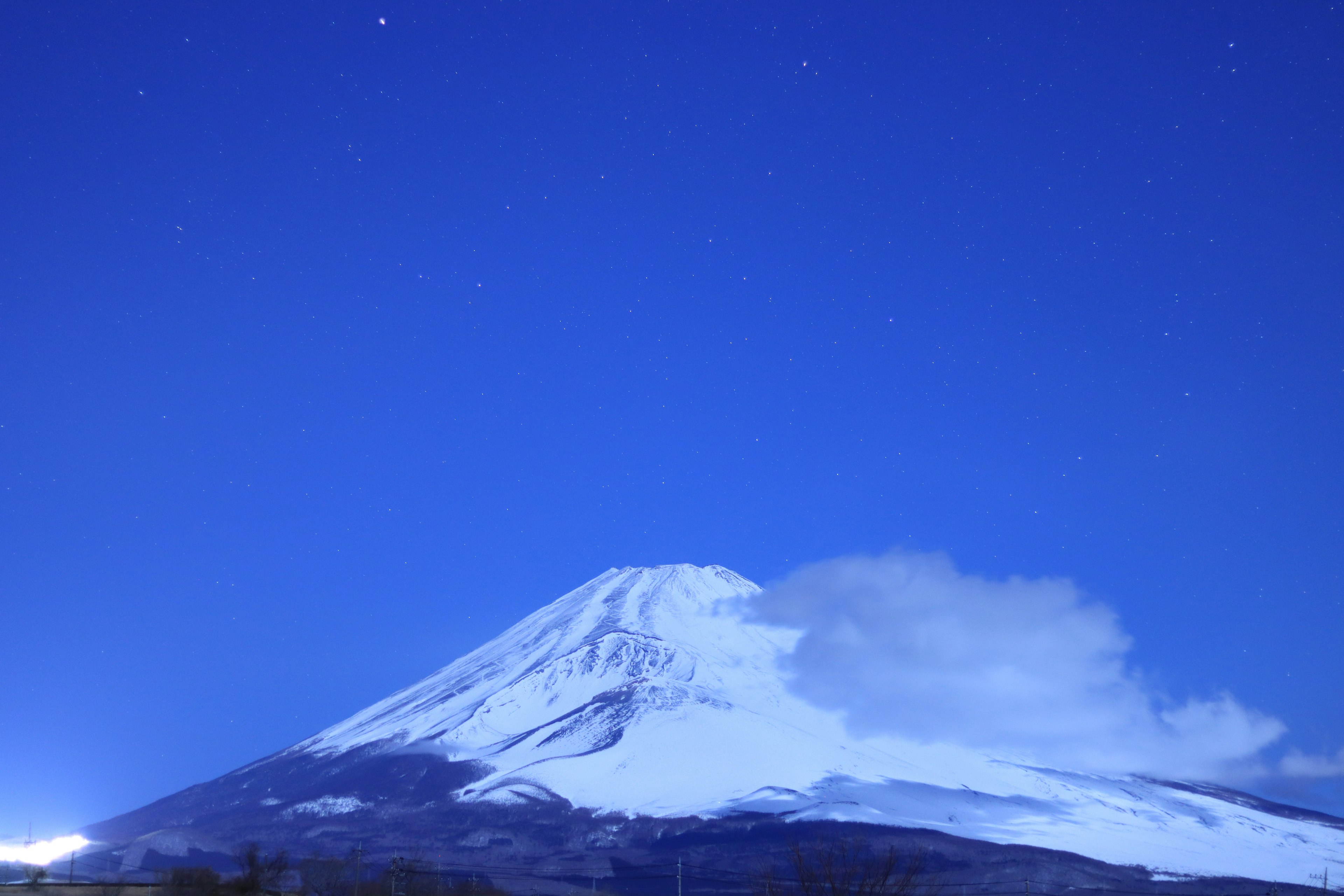 Der schneebedeckte Fuji erhebt sich unter einem klaren Nachthimmel