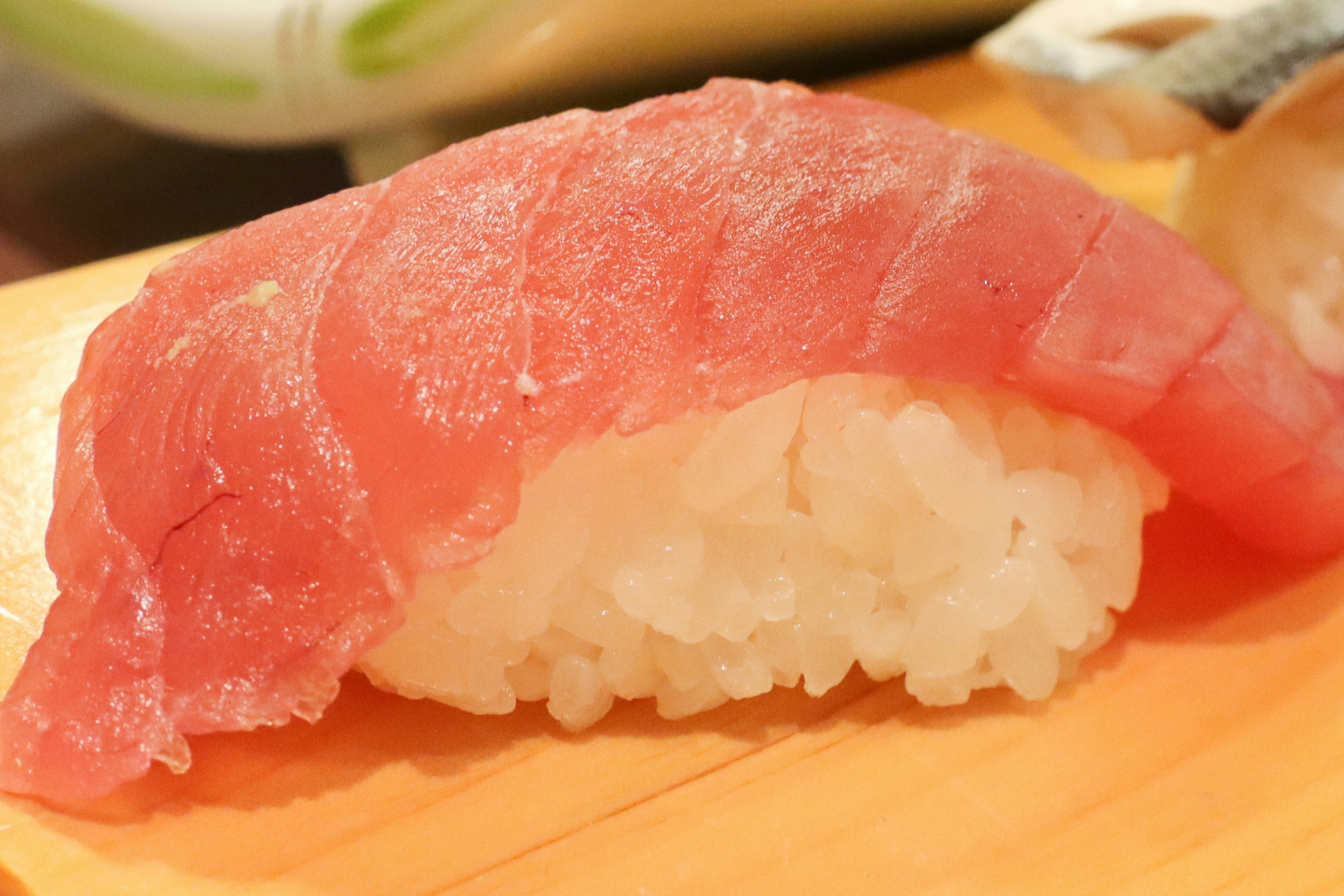 Fresh tuna nigiri sushi placed on a wooden board