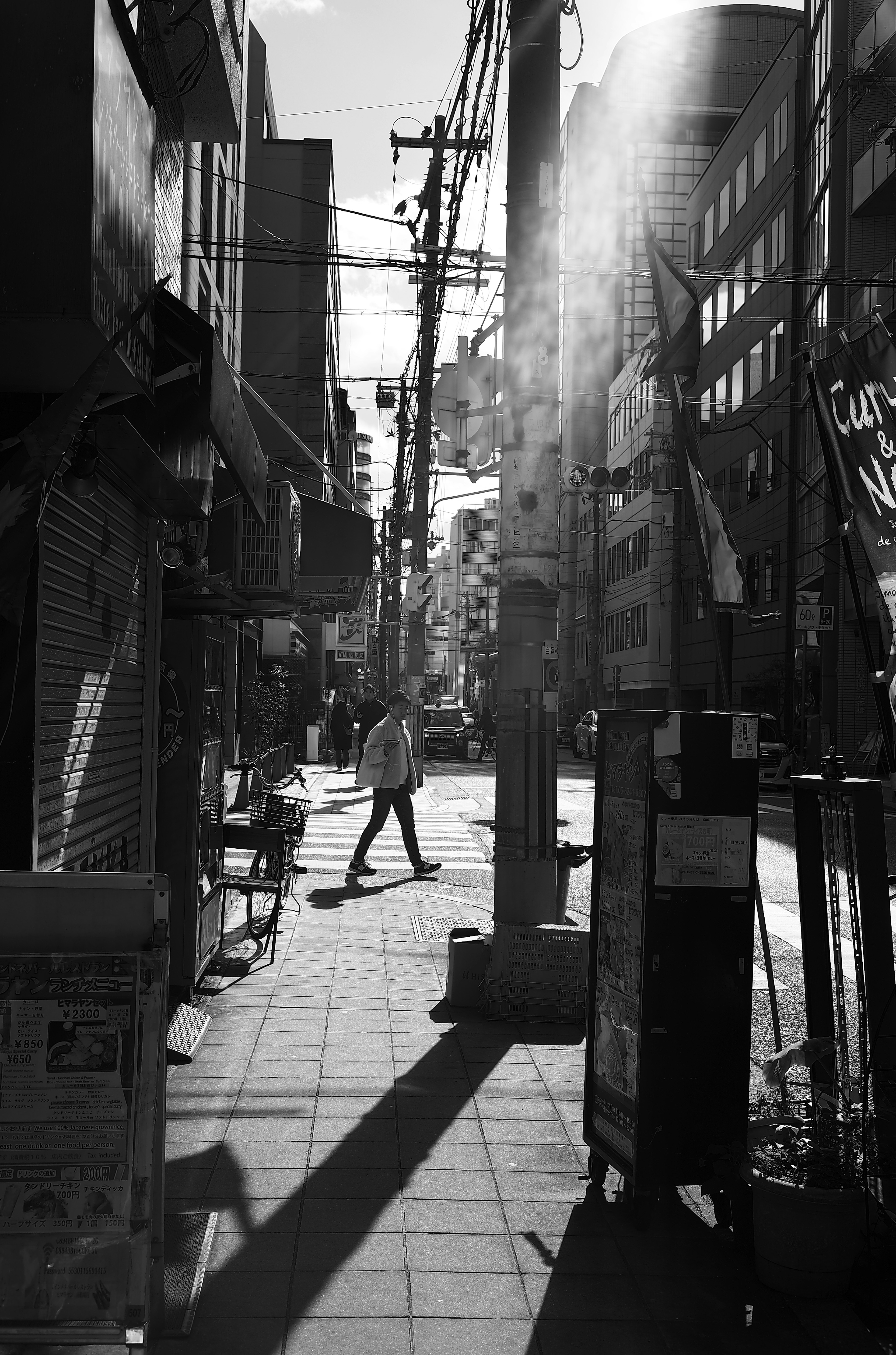 Una persona caminando en una escena de calle urbana en blanco y negro