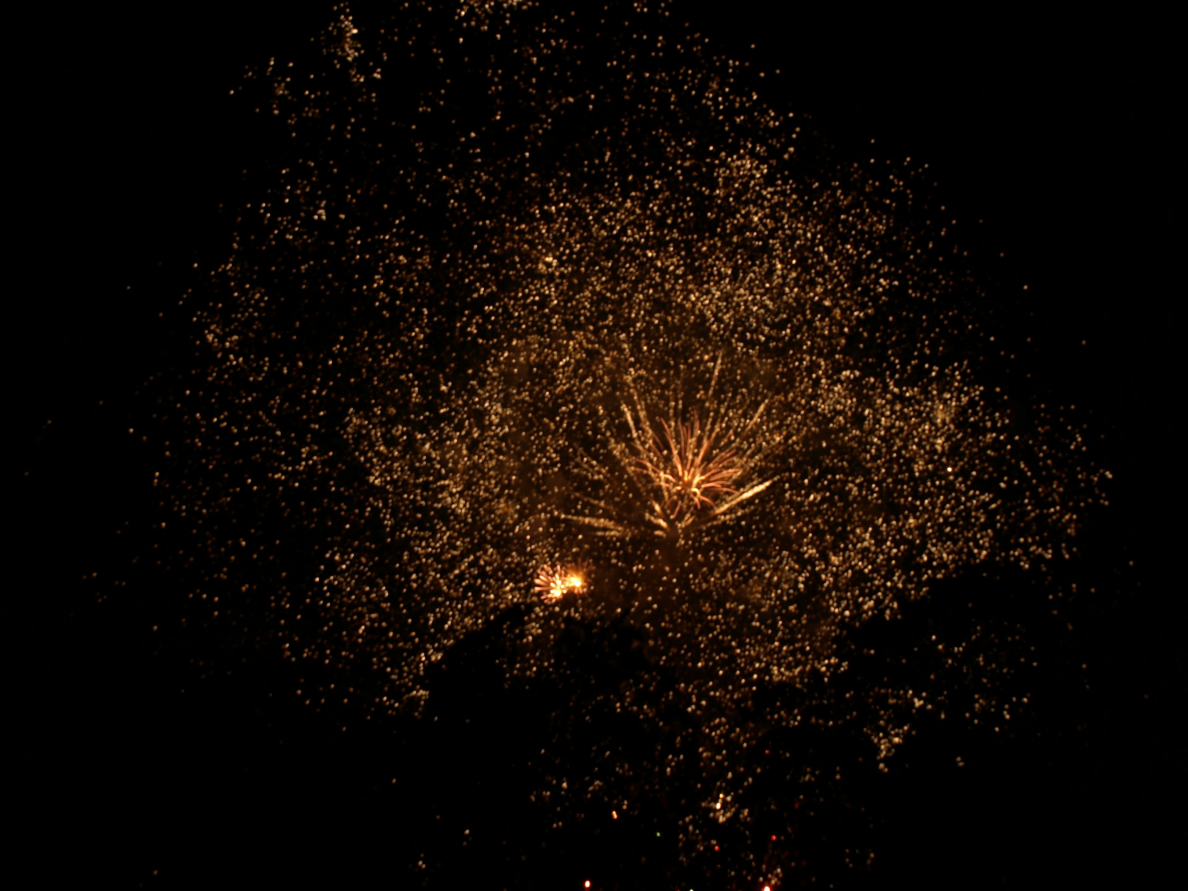 Golden sparks resembling fireworks illuminating the night sky