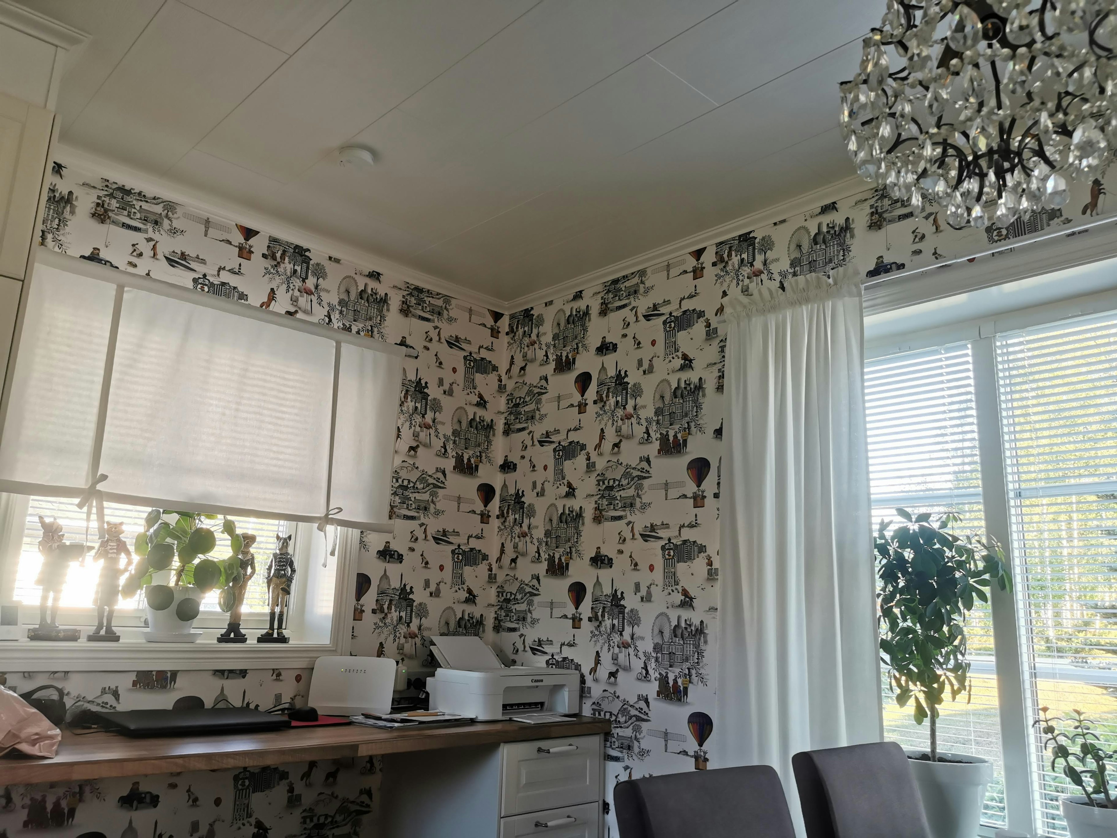 Bright dining area with monochrome patterned wallpaper and potted plants