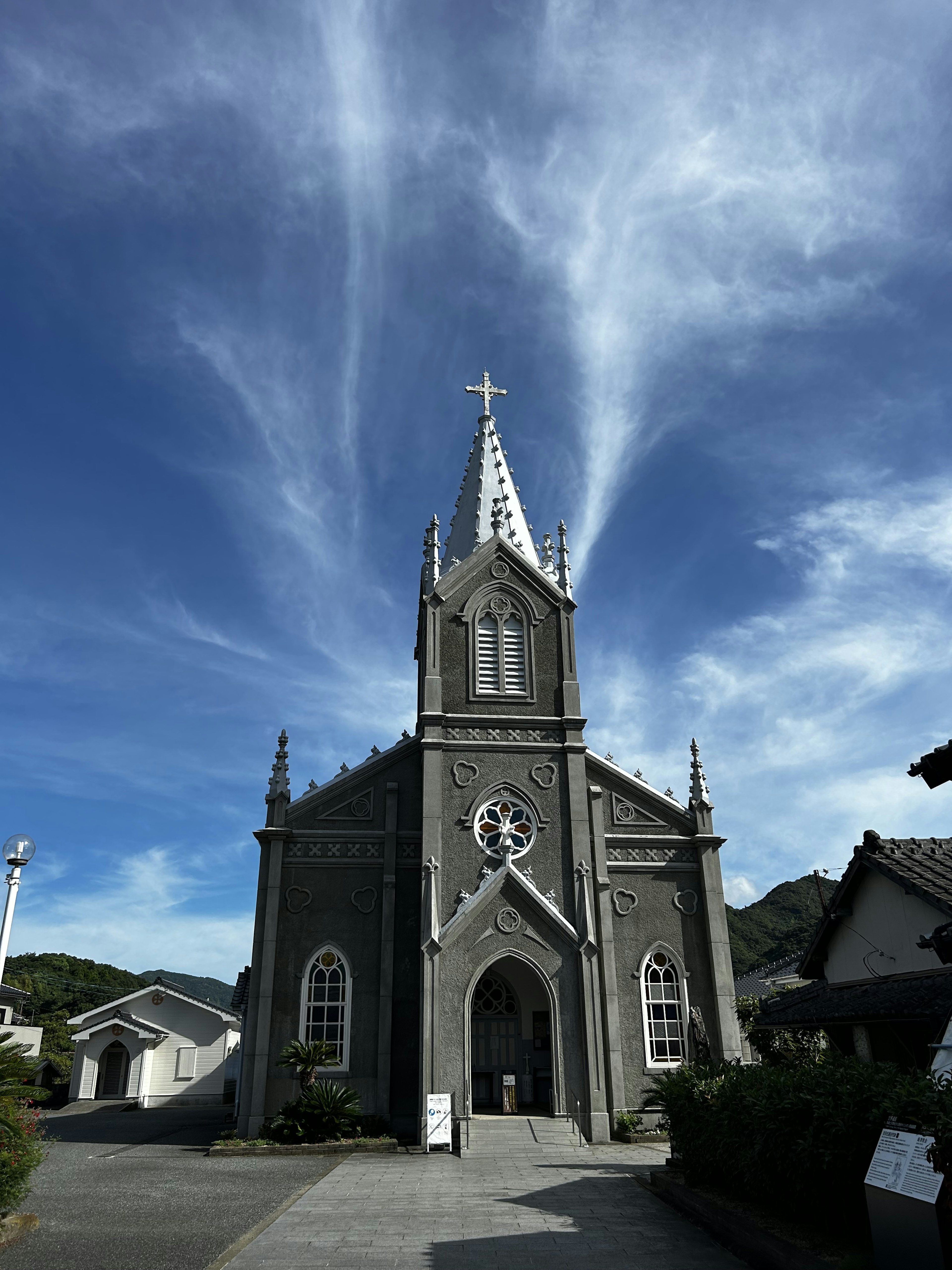 Gereja abu-abu dengan arsitektur unik di bawah langit biru