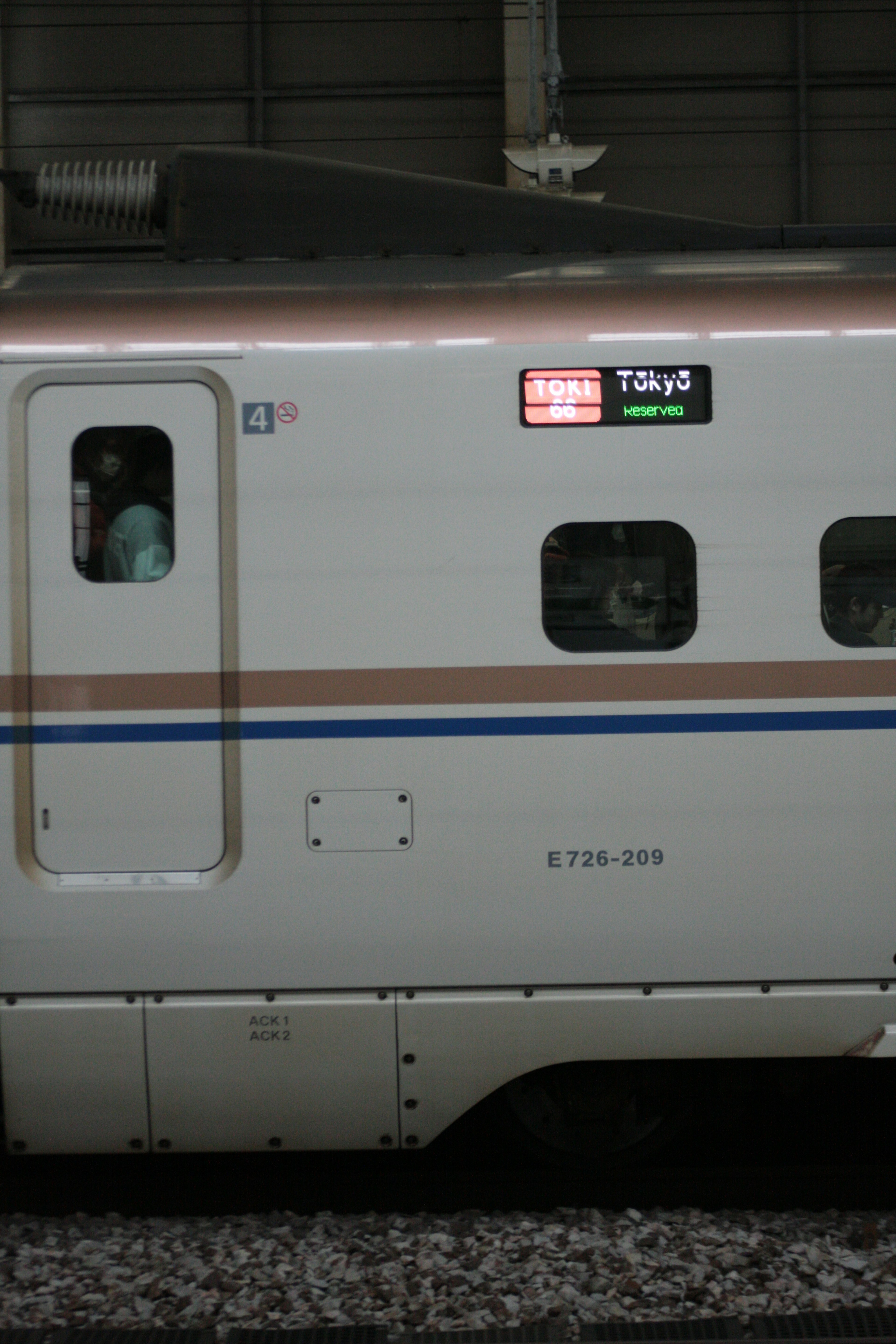 Side view of a Shinkansen train with a window and display panel