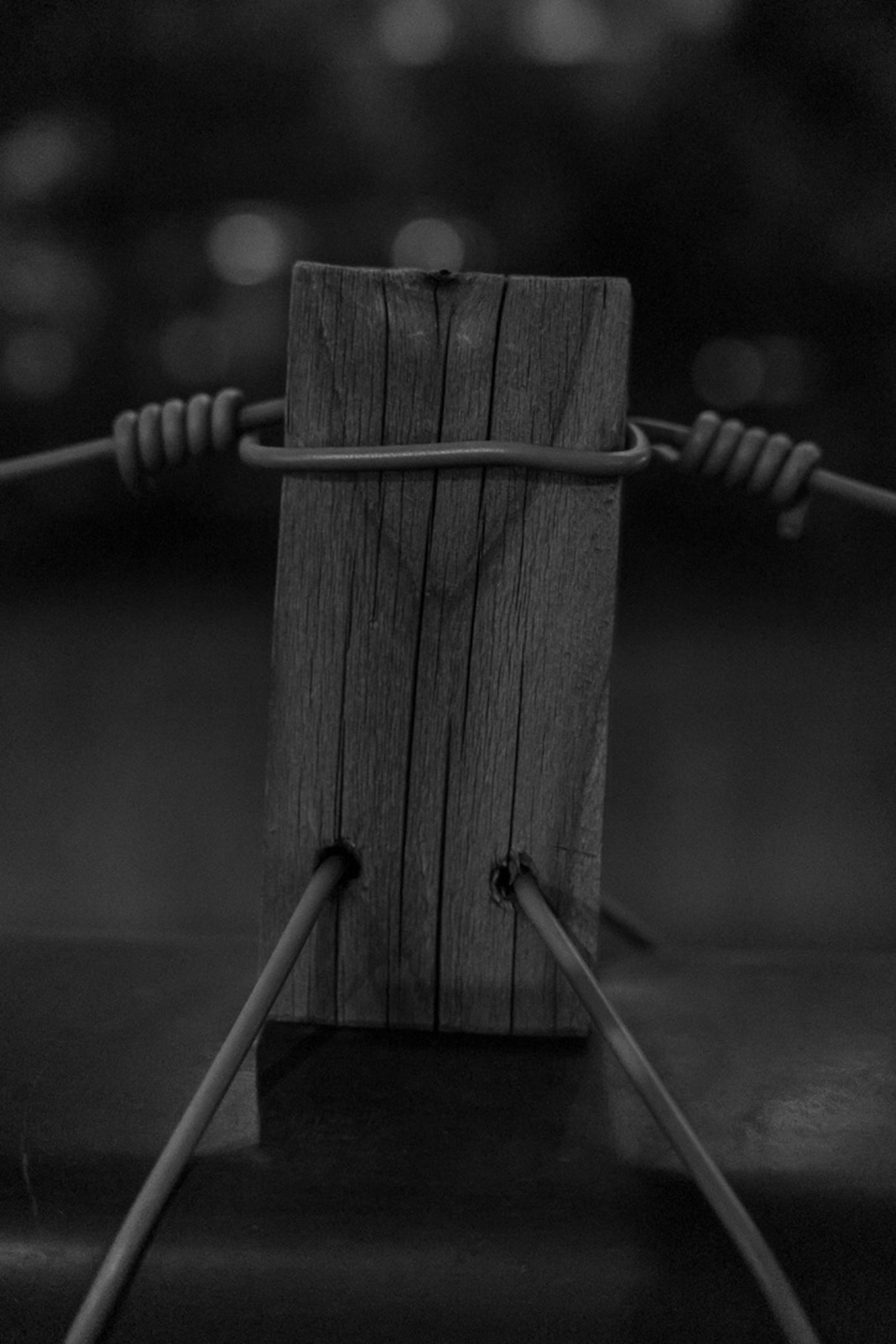 Close-up image of a wooden post connected with wire