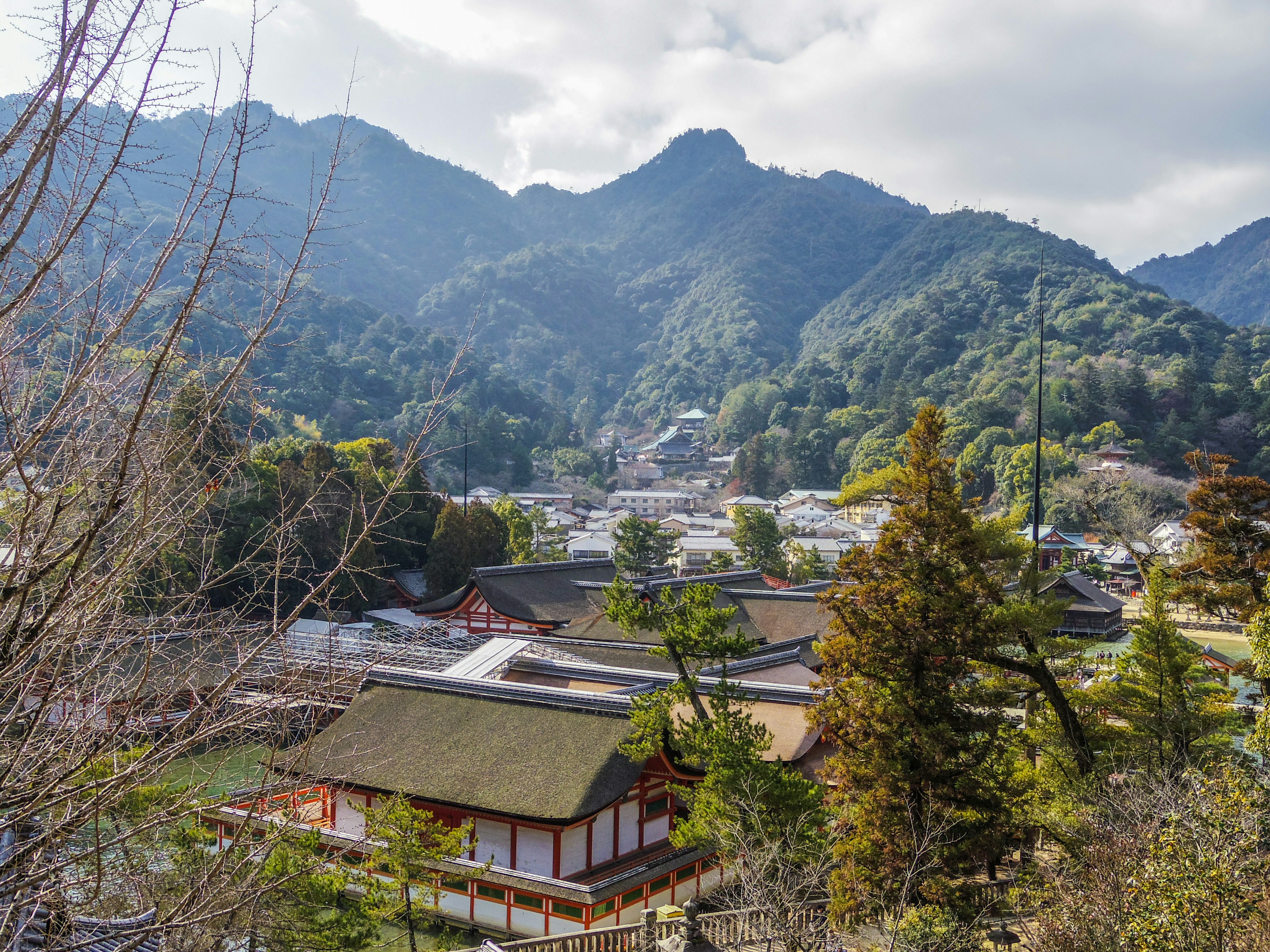 山々に囲まれた伝統的な日本の建物と緑豊かな風景