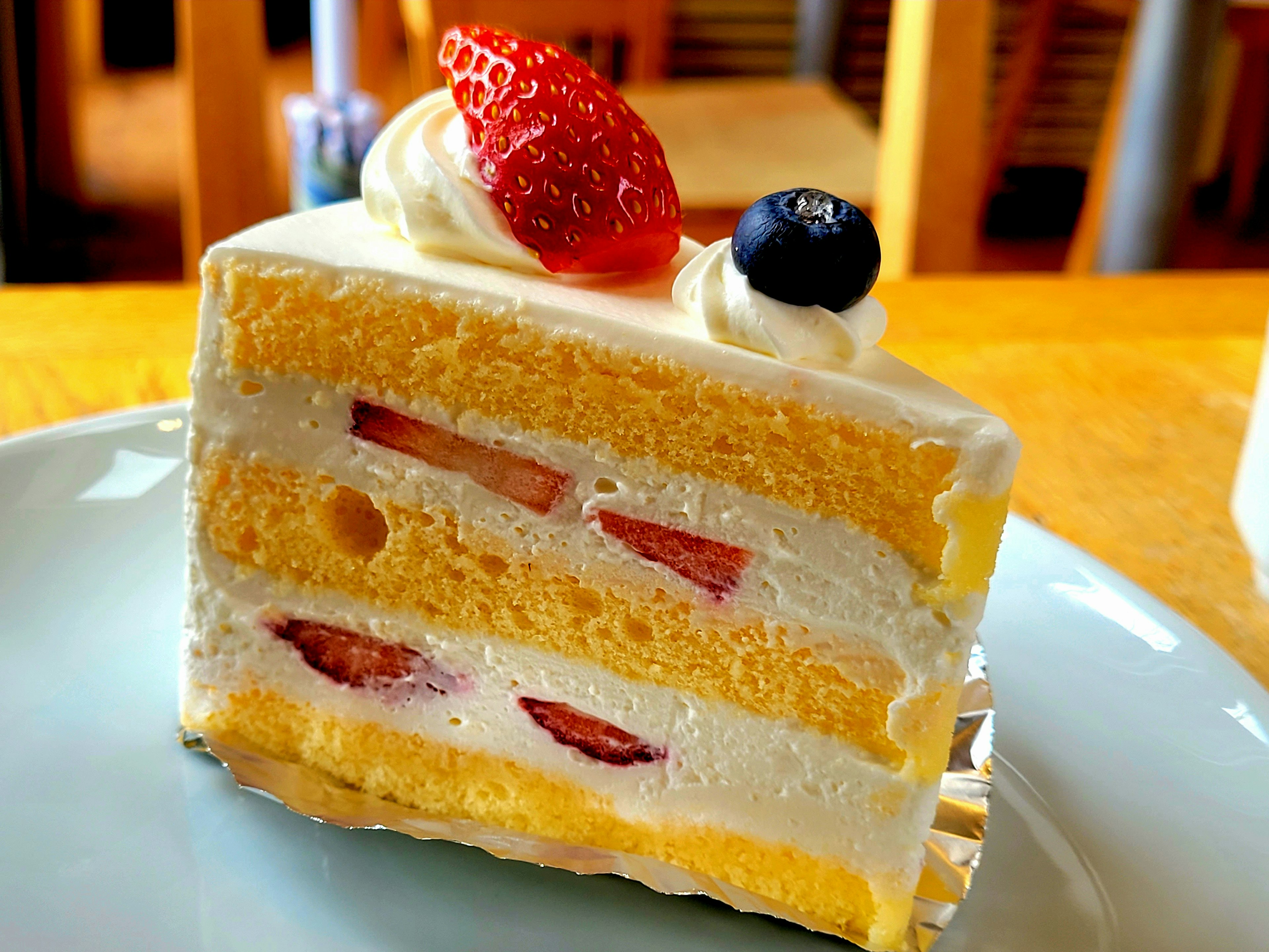 Scheibe gelber Biskuitkuchen mit Sahne und Erdbeeren