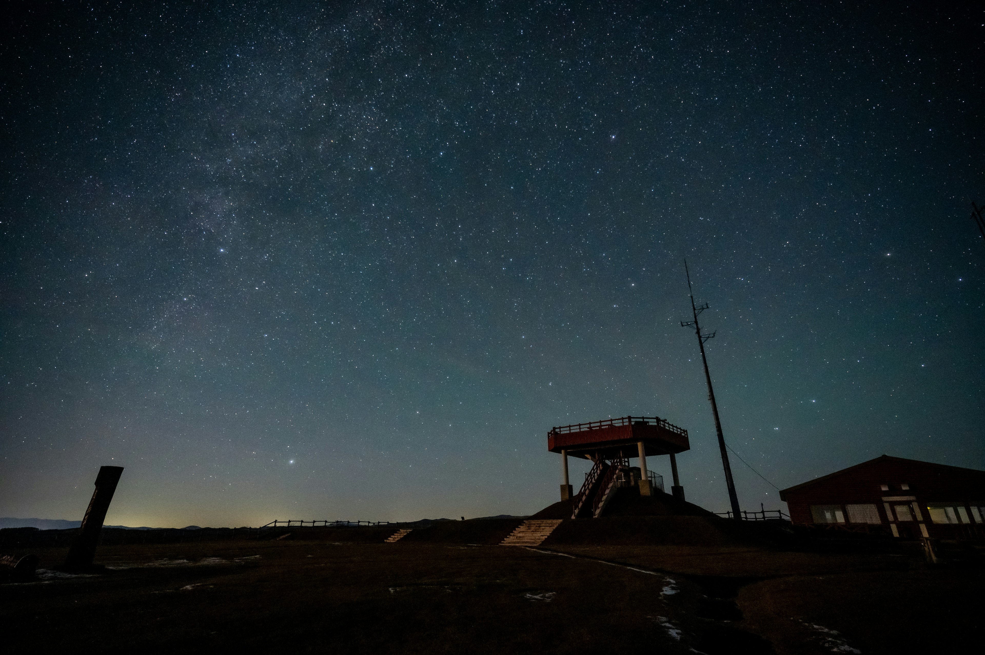 Un edificio e una torre di comunicazione sotto un cielo stellato