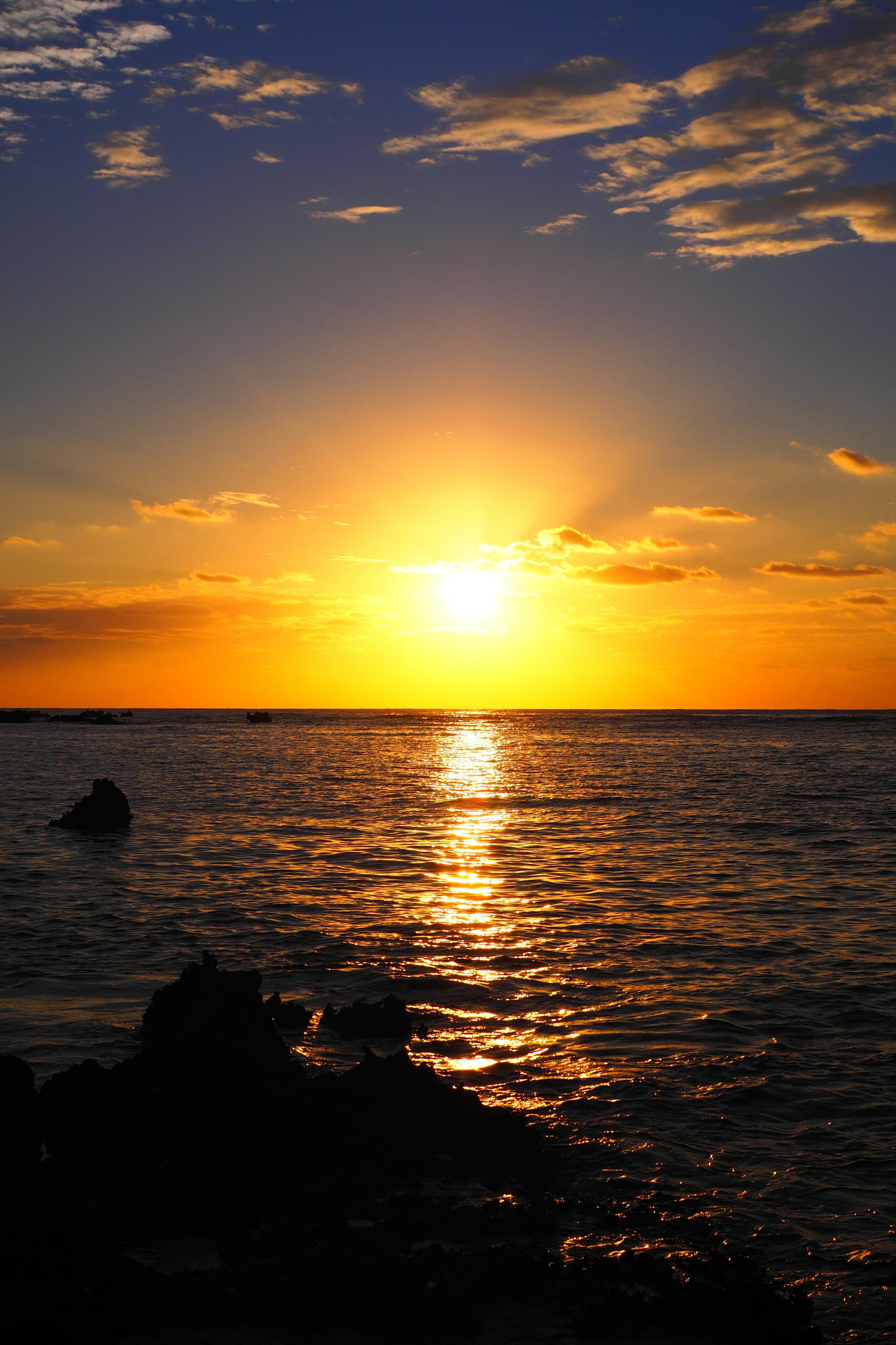 Un bellissimo tramonto sull'oceano con cieli arancioni e blu