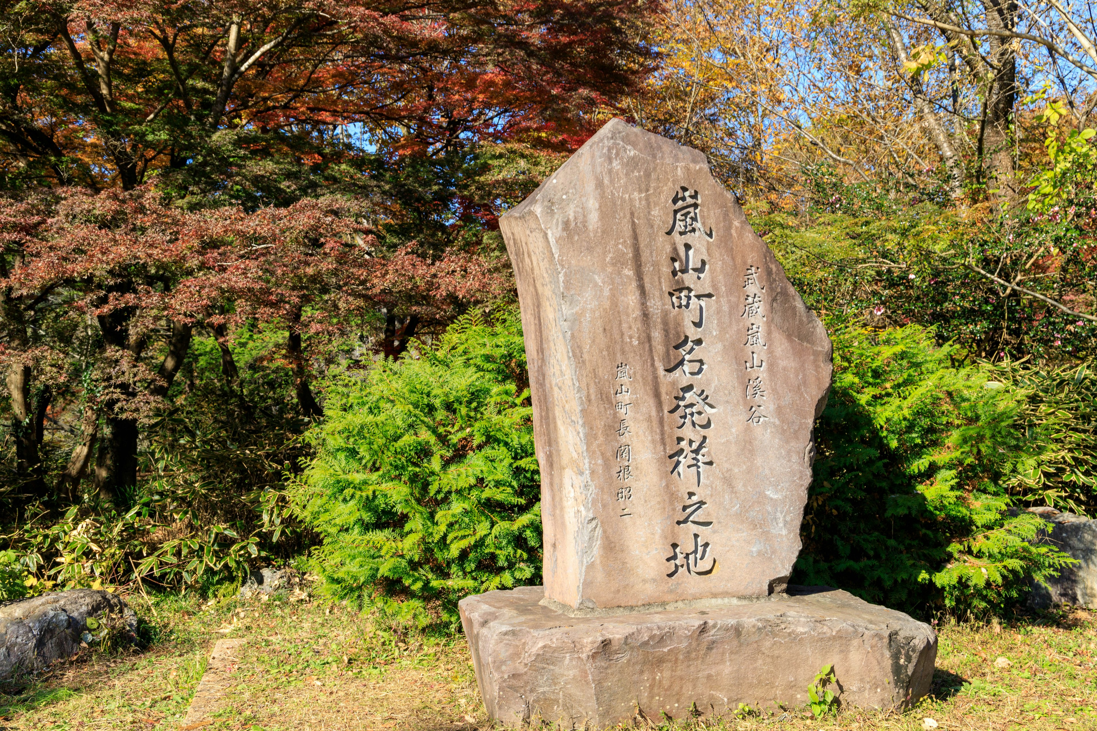 Monument en pierre entouré de nature avec des feuilles d'automne en arrière-plan