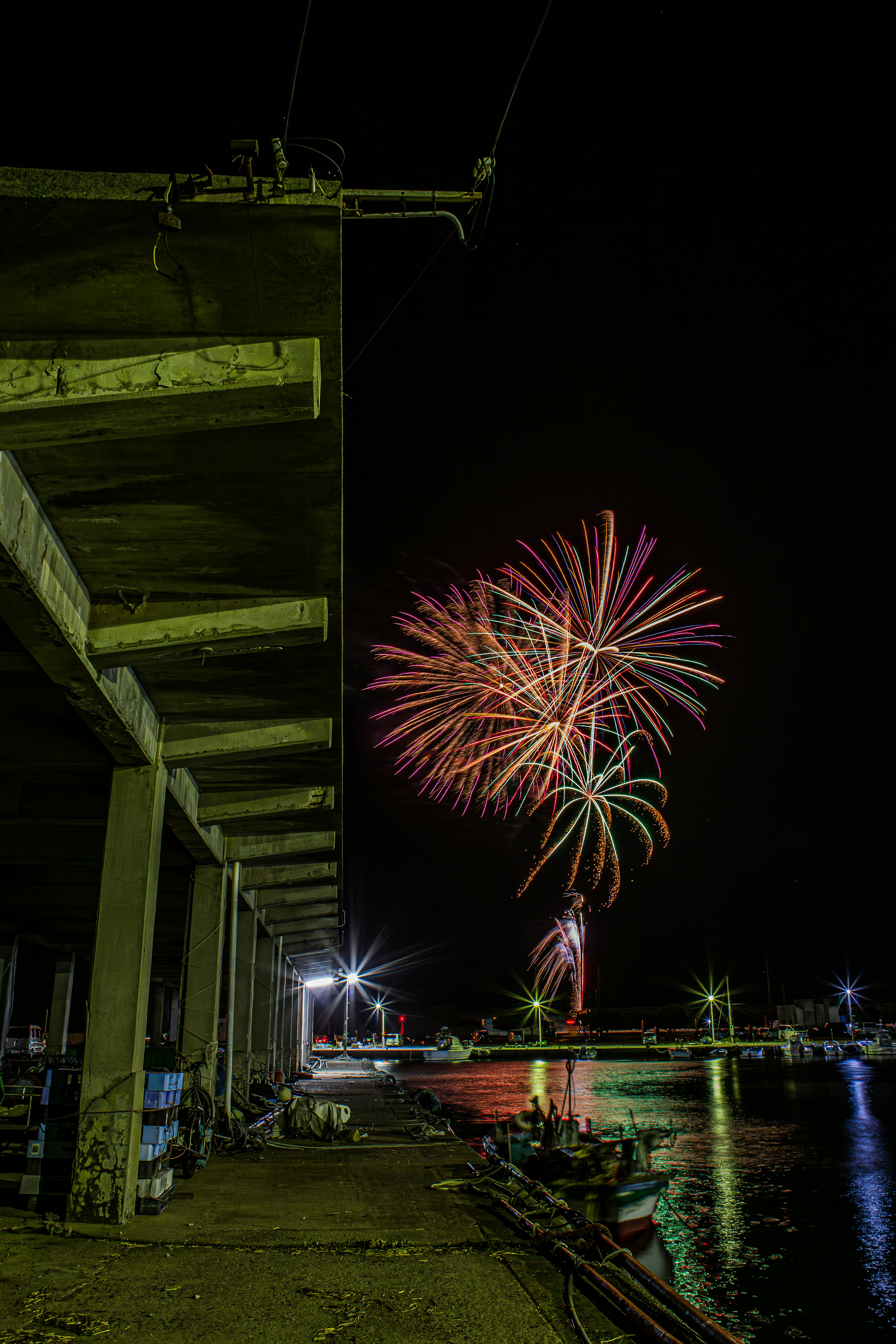 Des feux d'artifice illuminant le ciel nocturne au-dessus d'un port