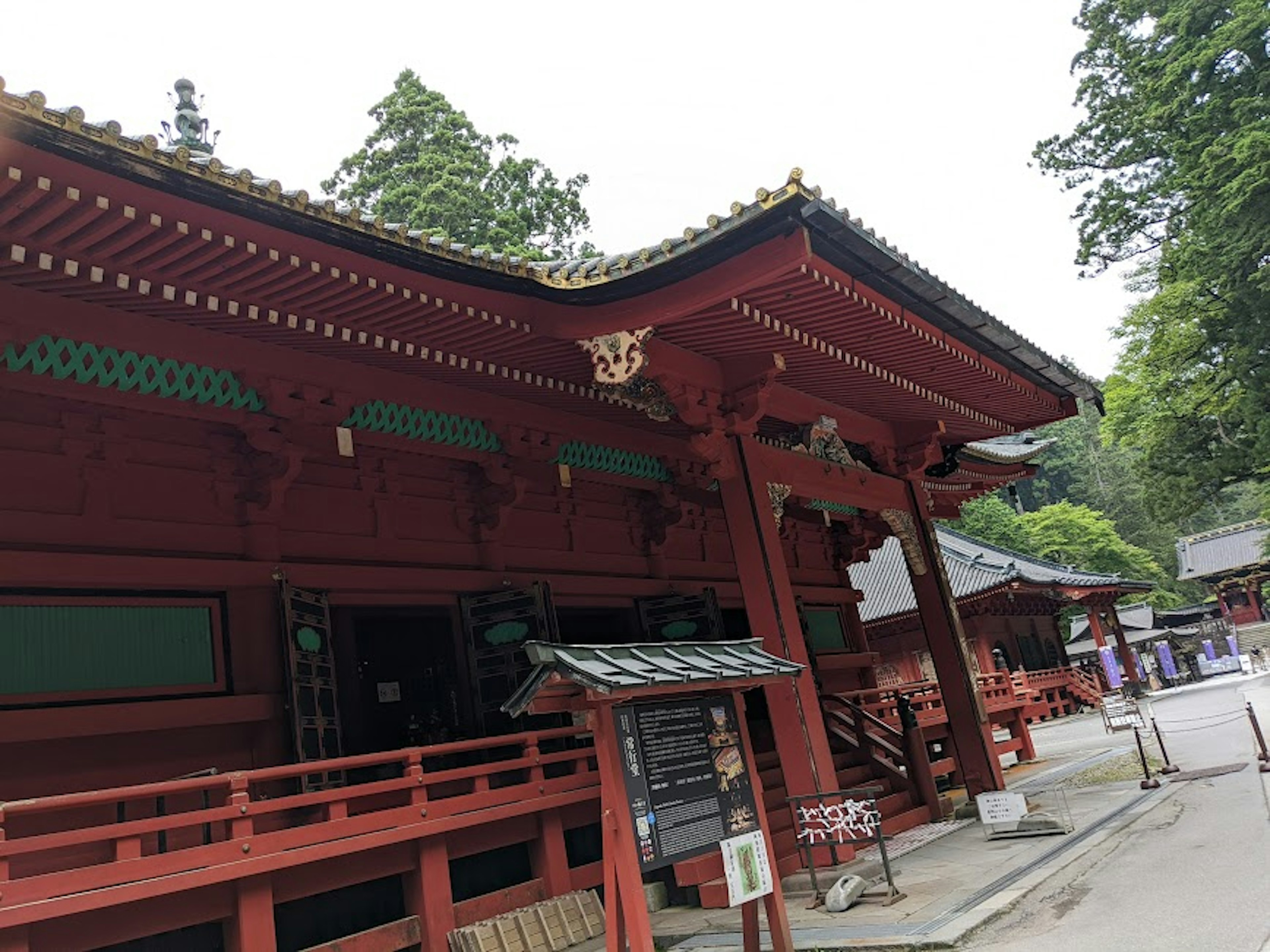 Exterior of a shrine featuring red architecture and green decorations