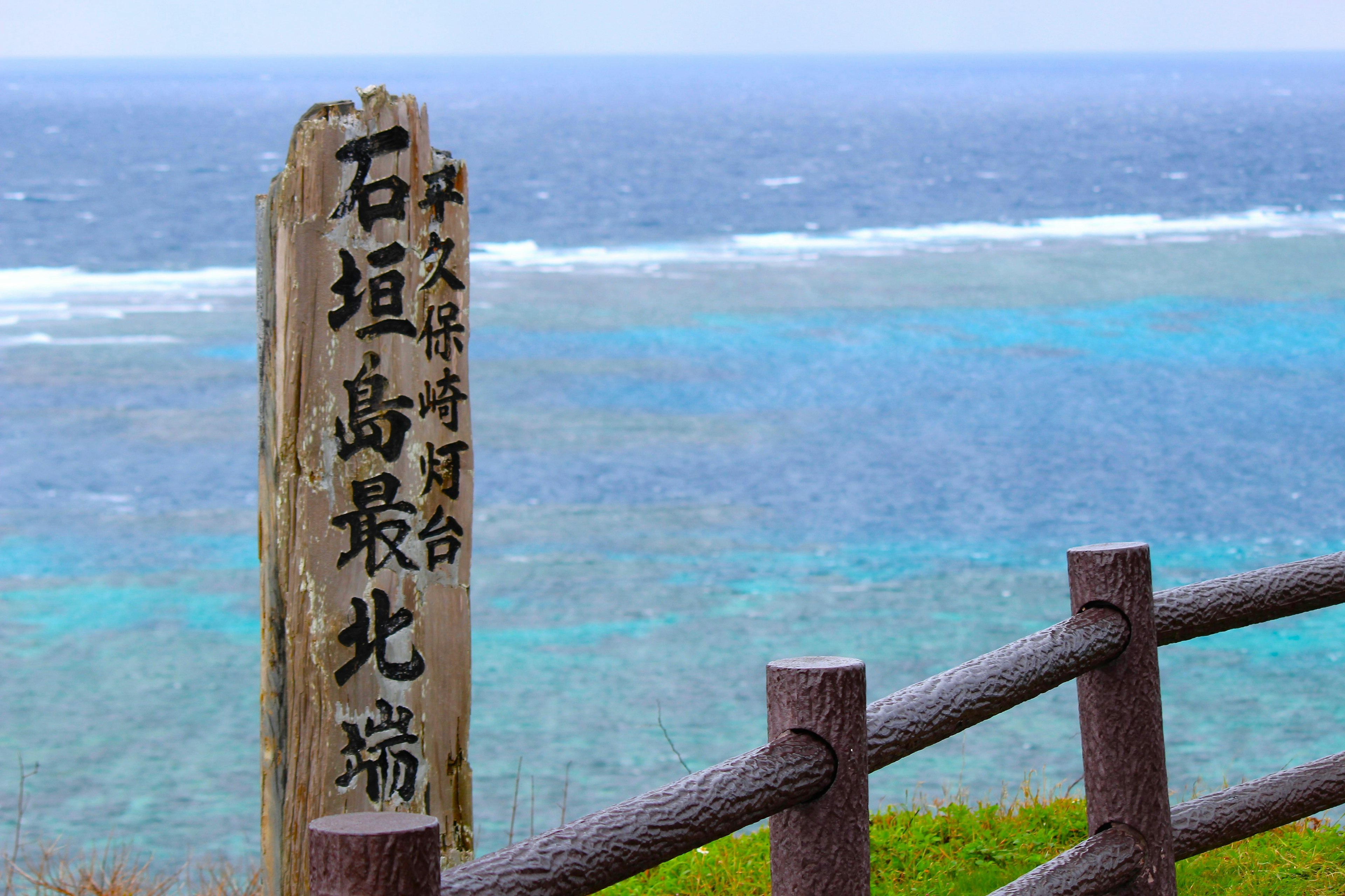 指示石垣島最北端的標誌牌，背景為海洋