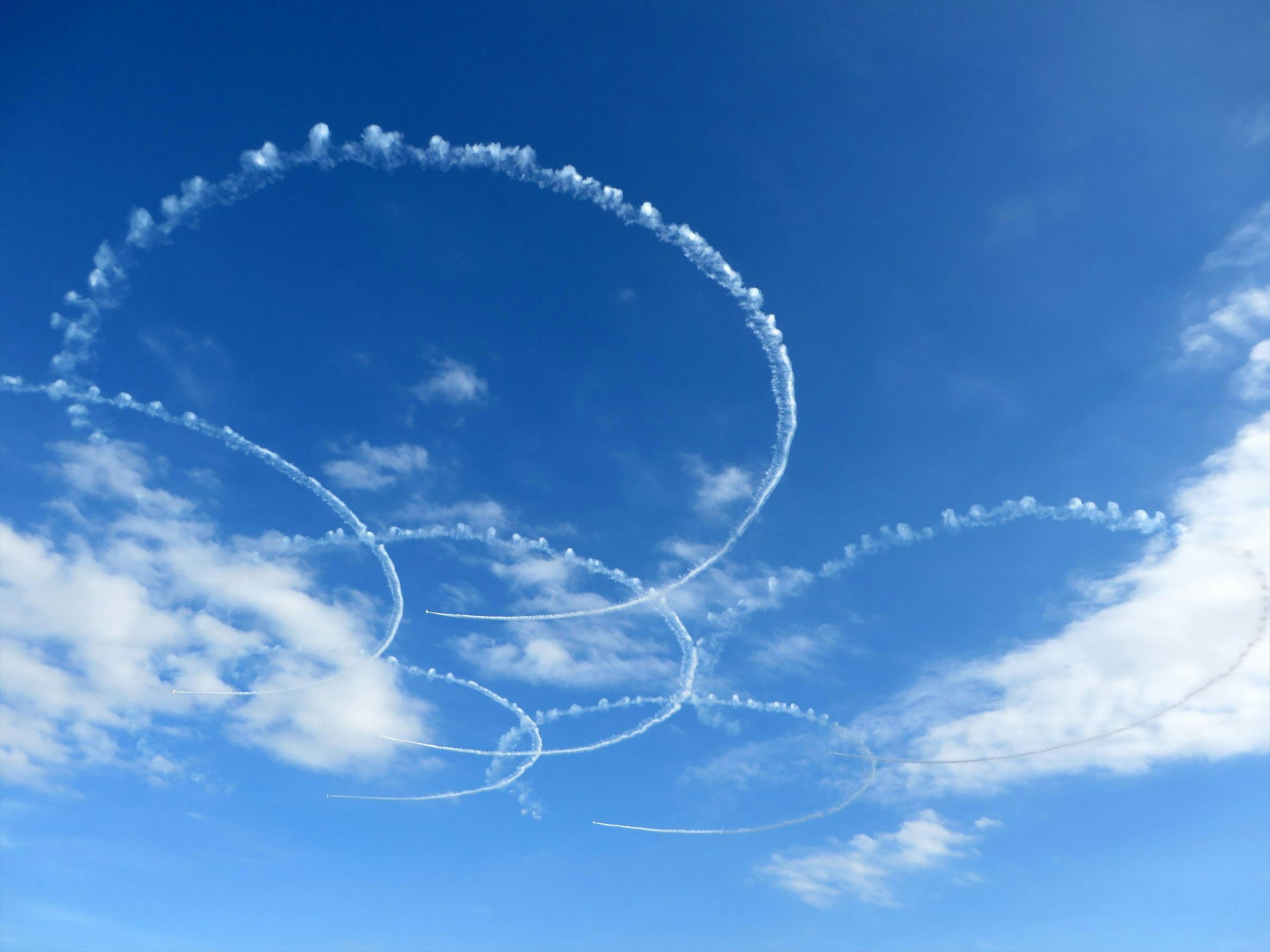 Lingkaran asap di langit biru dengan awan