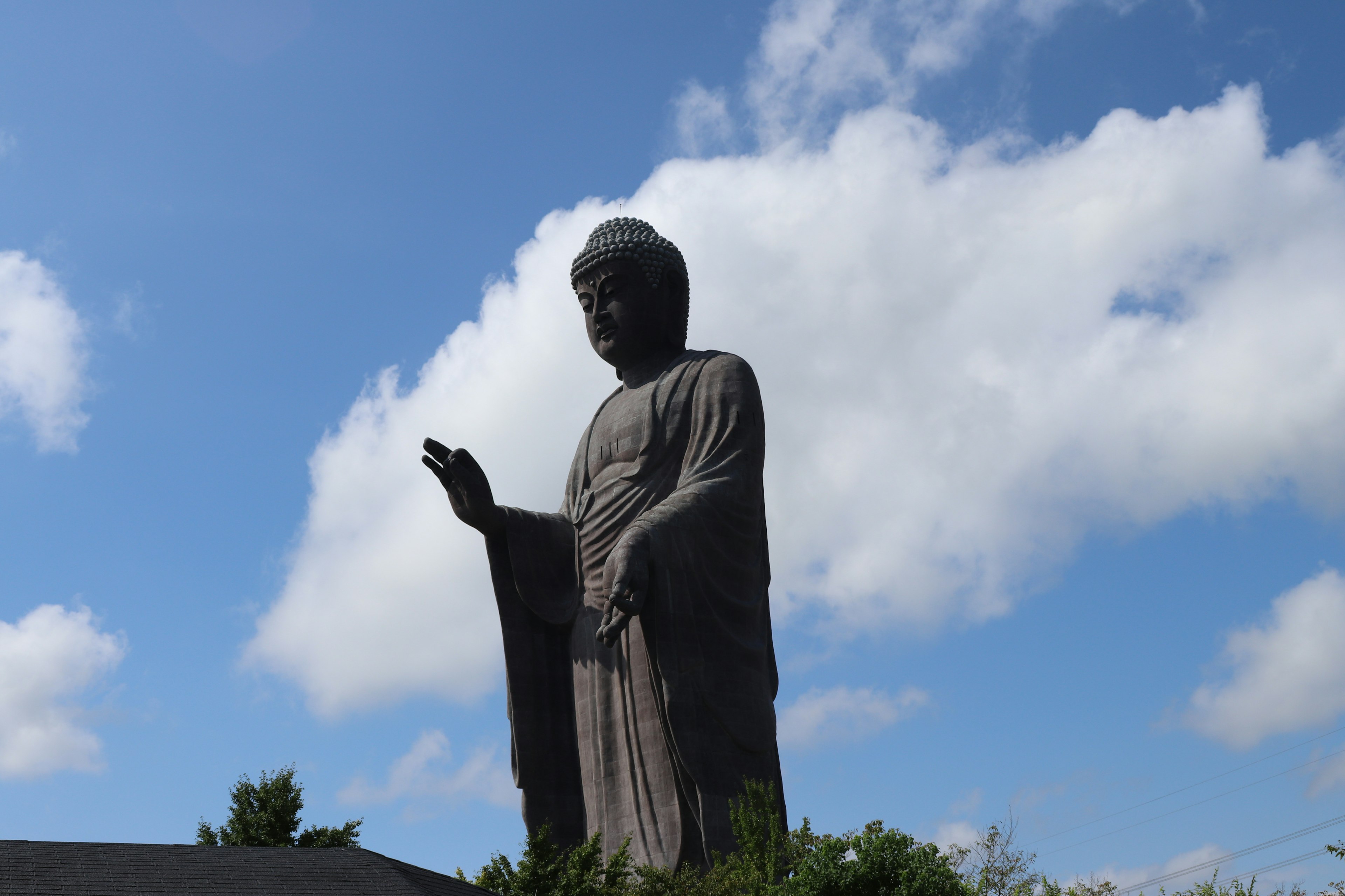 Large Buddha statue standing under a blue sky