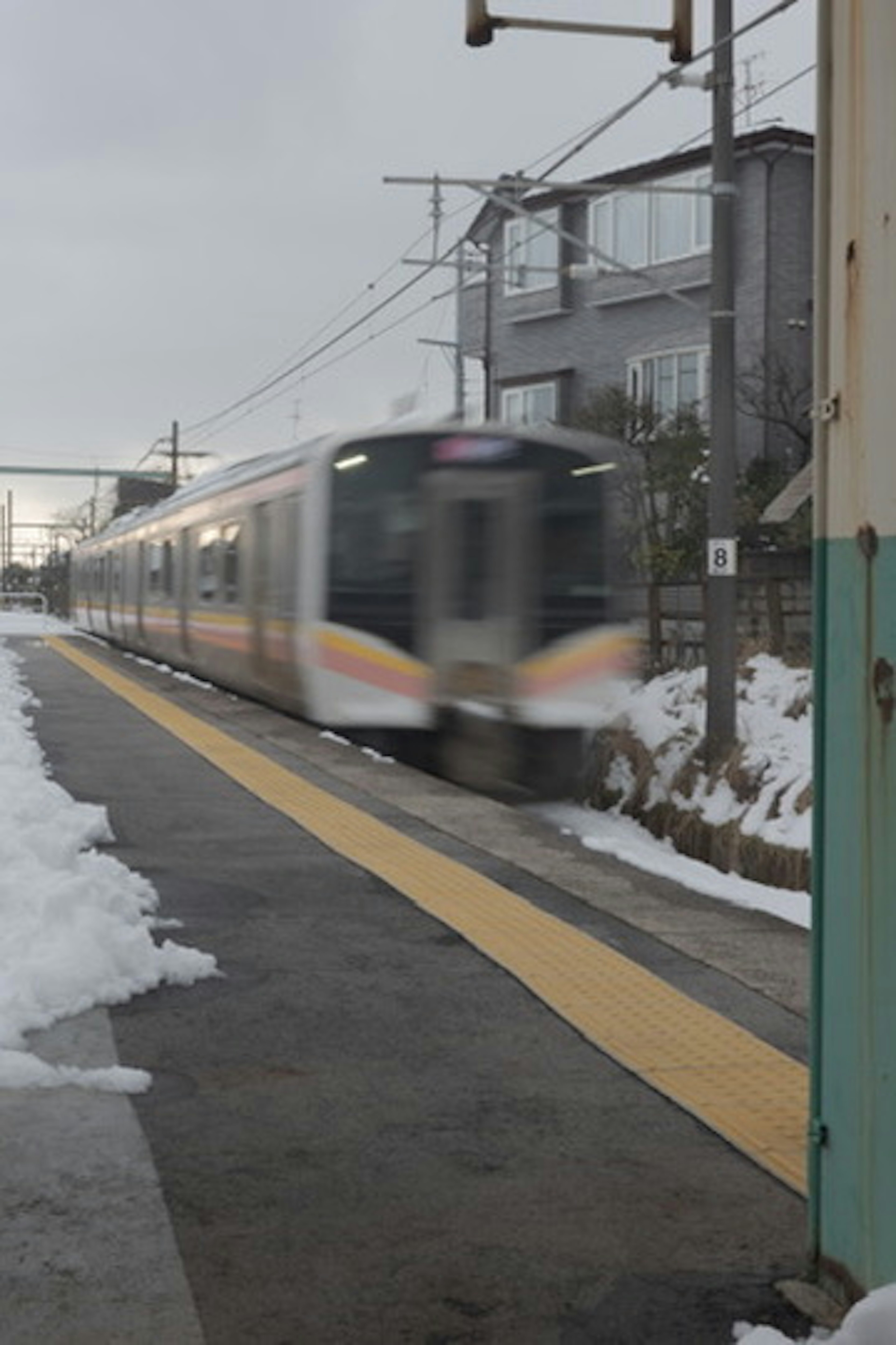 รถไฟที่ผ่านไปยังชานชาลาที่มีหิมะ