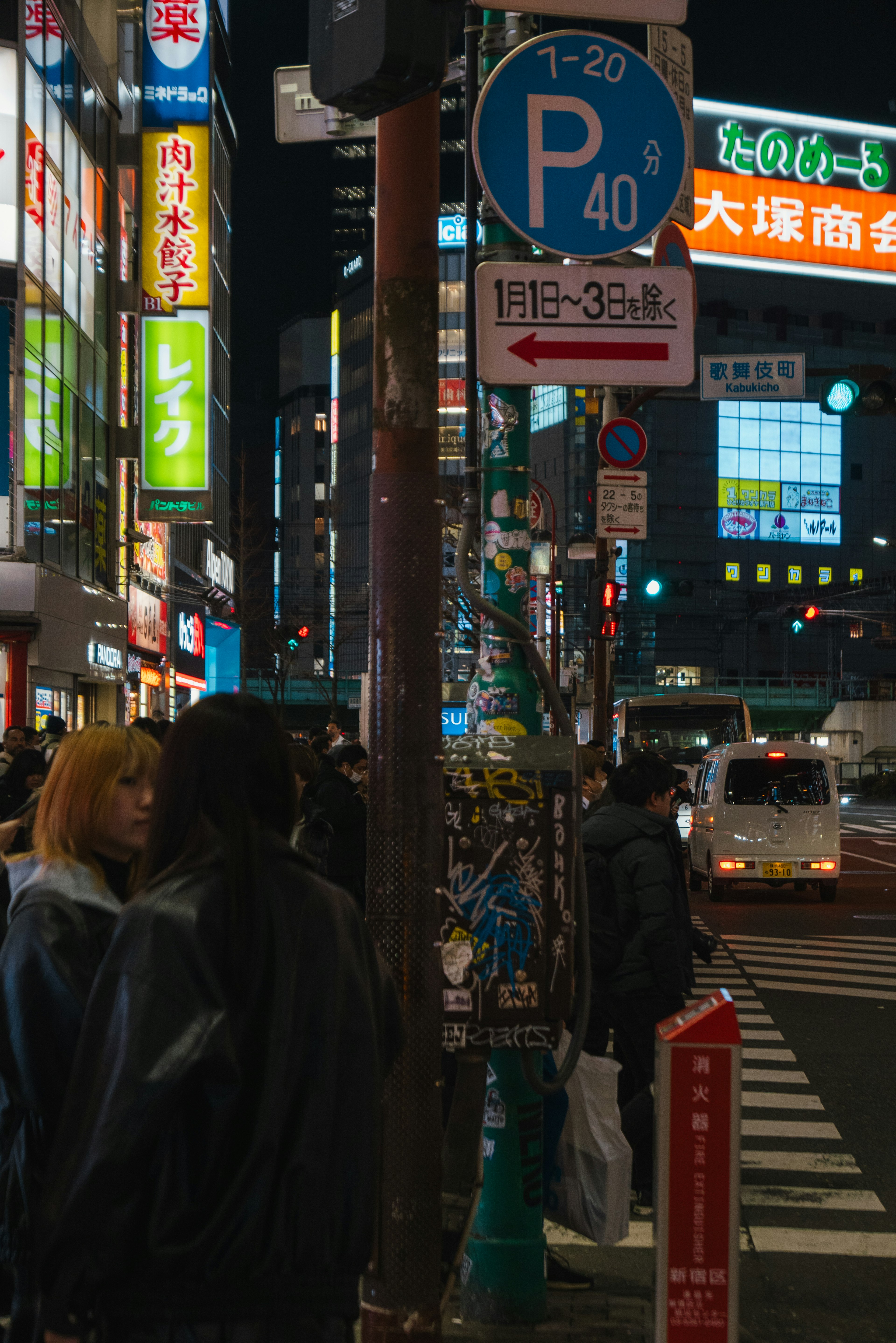 Nächtliche Stadtstraße mit Menschen und bunten Schildern in einer japanischen urbanen Umgebung