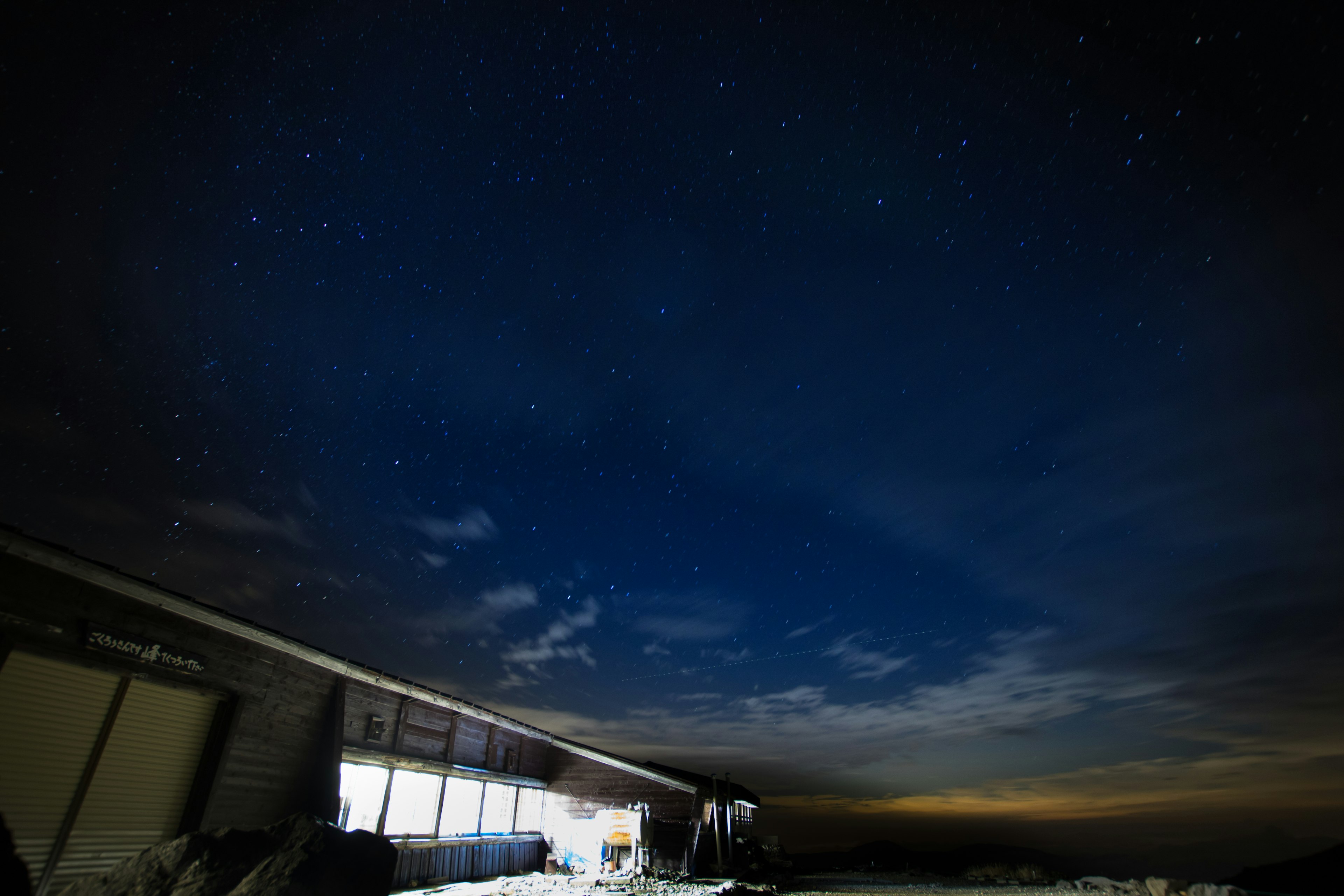 Silueta de un edificio bajo un cielo estrellado con nubes