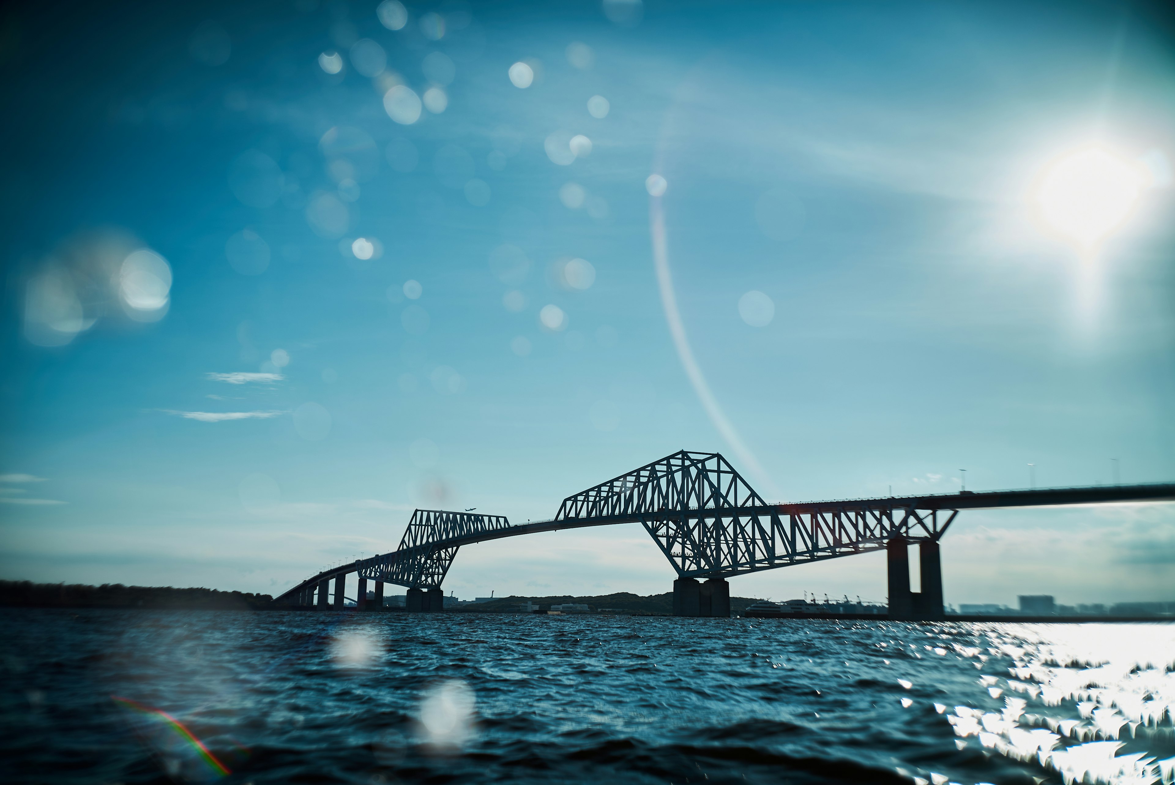 Bridge spanning over water under a blue sky