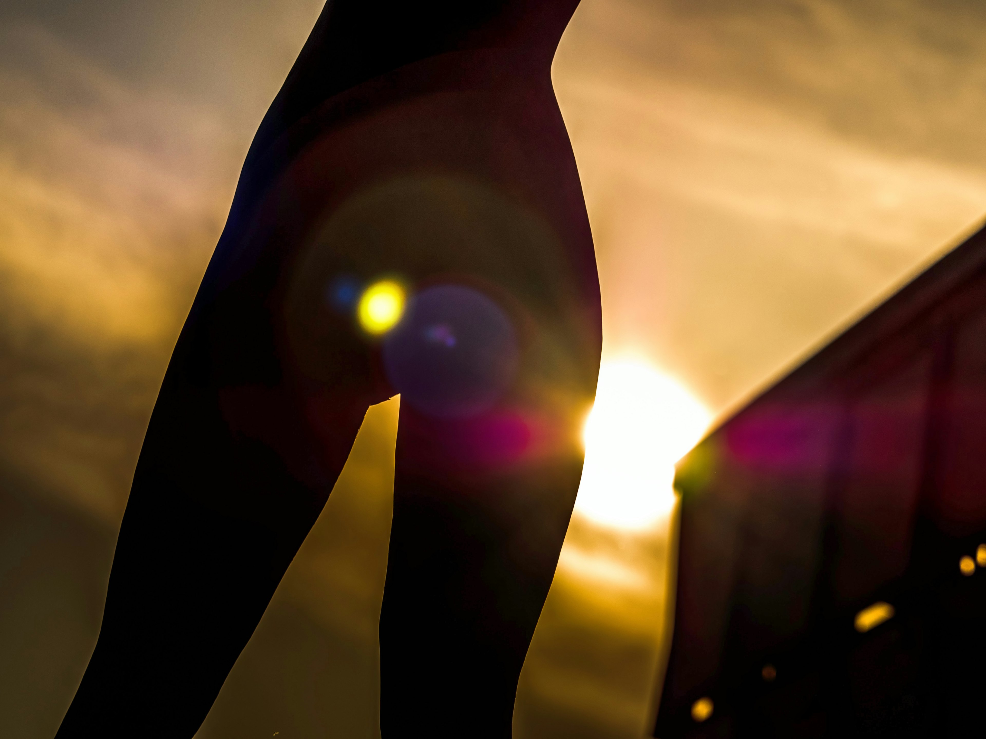 Silhouette der Beine einer Person vor einem Sonnenuntergang