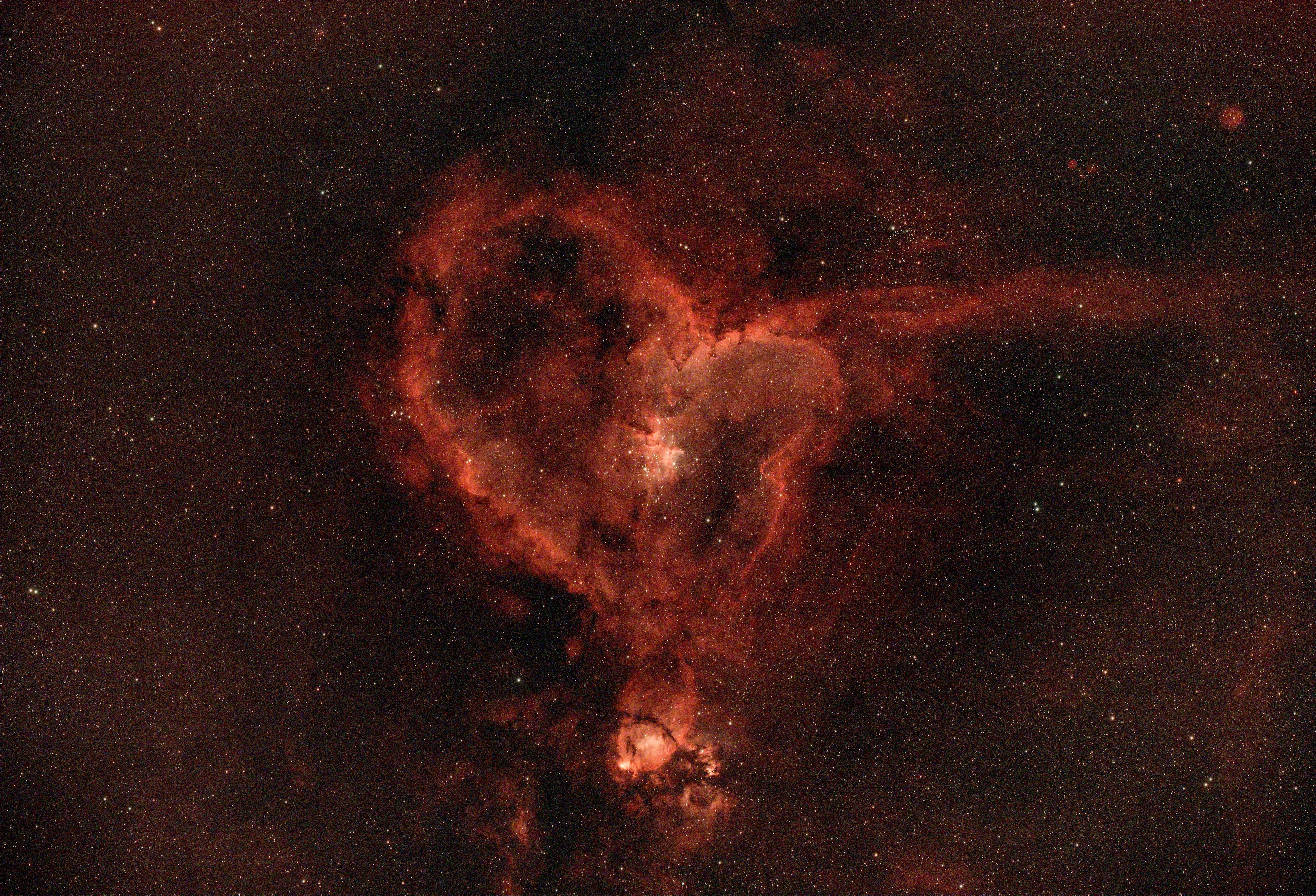 Nebulosa en forma de corazón con estrellas circundantes en una impresionante vista cósmica