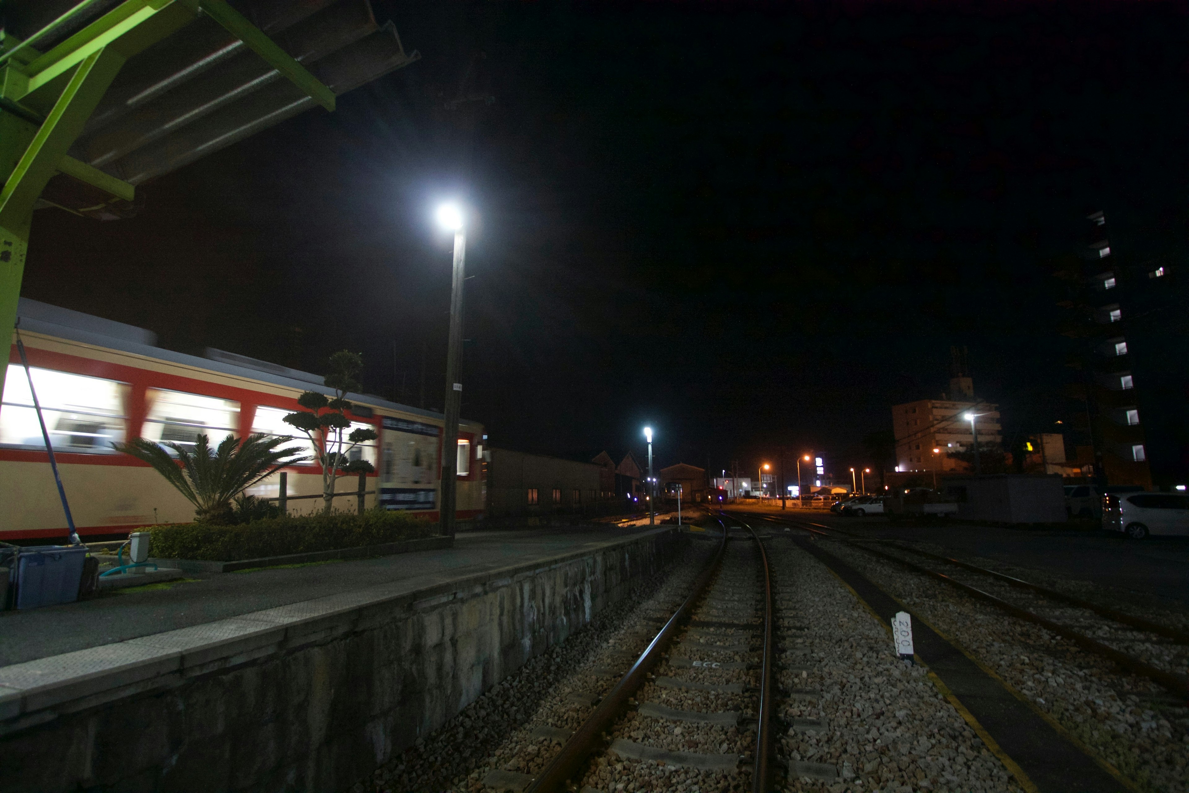 Nighttime view of a train station with illuminated platforms