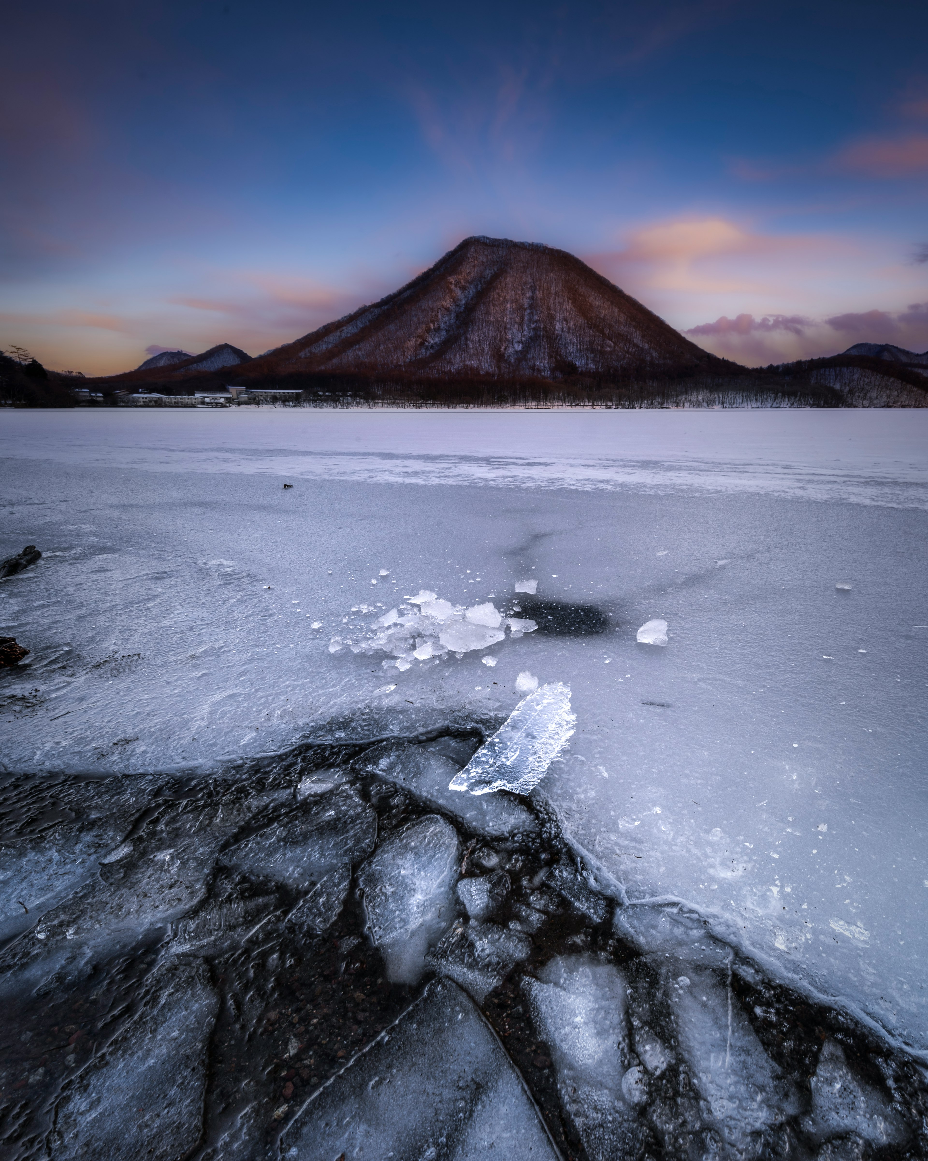 氷に覆われた湖と雪に覆われた山の風景