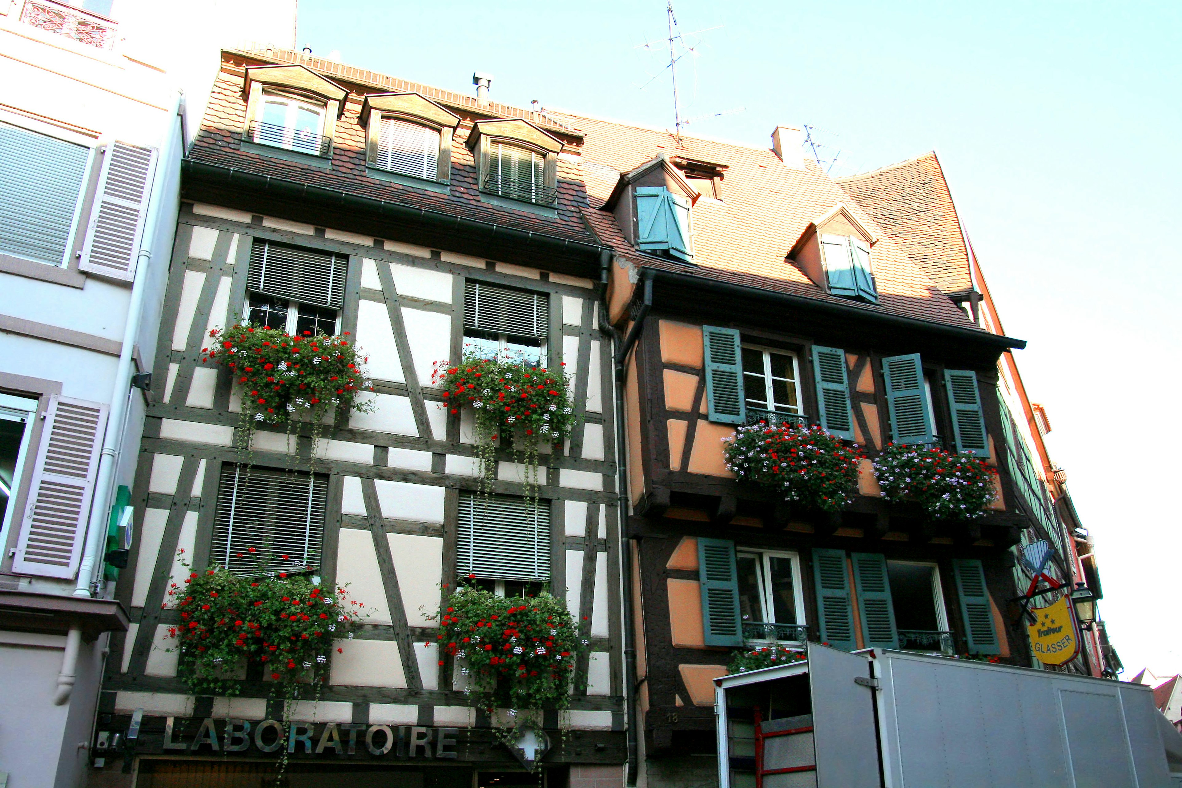 Facade of traditional half-timbered houses in Strasbourg featuring flower-adorned balconies