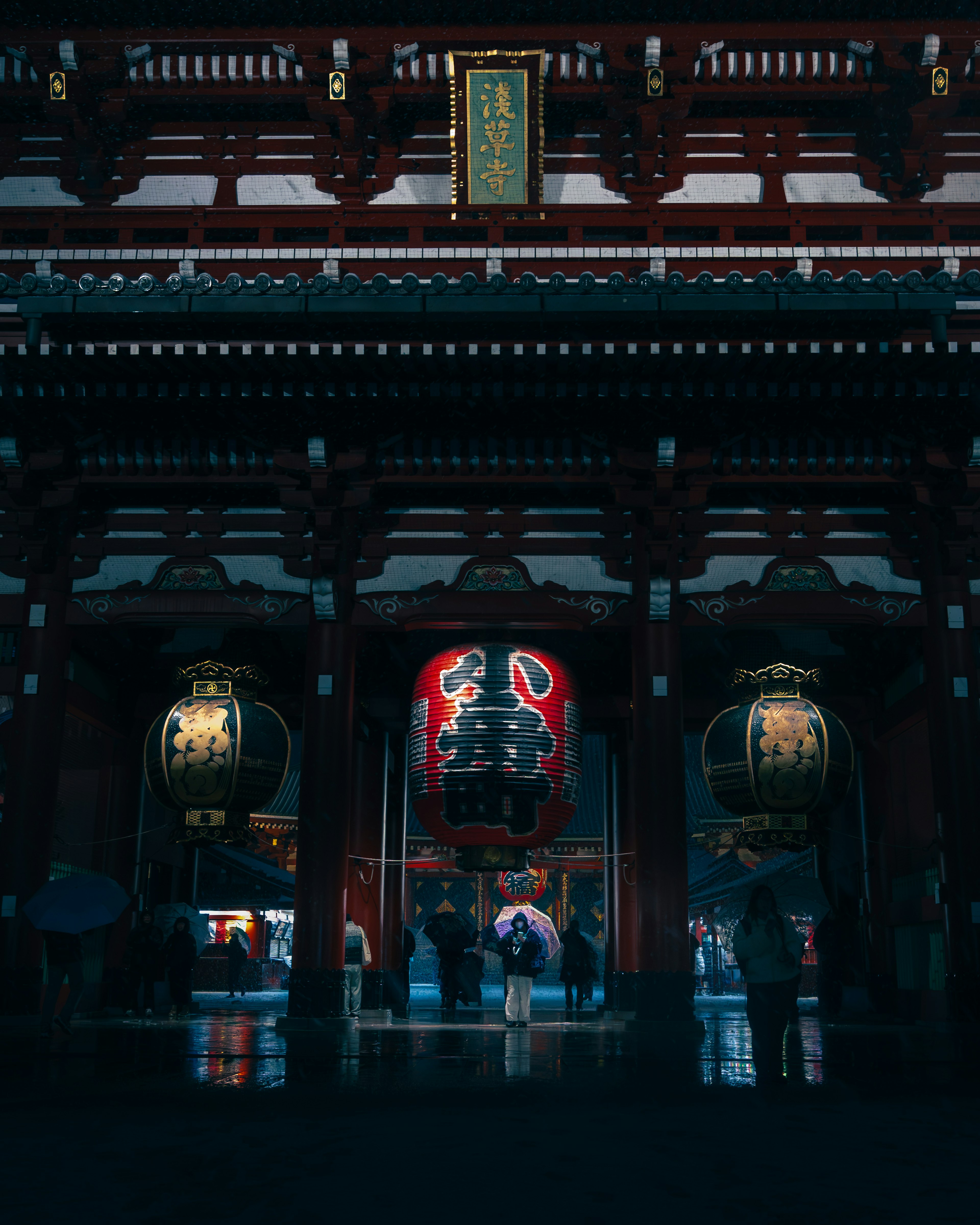 Vista nocturna del templo Senso-ji con grandes faroles y arquitectura de madera roja