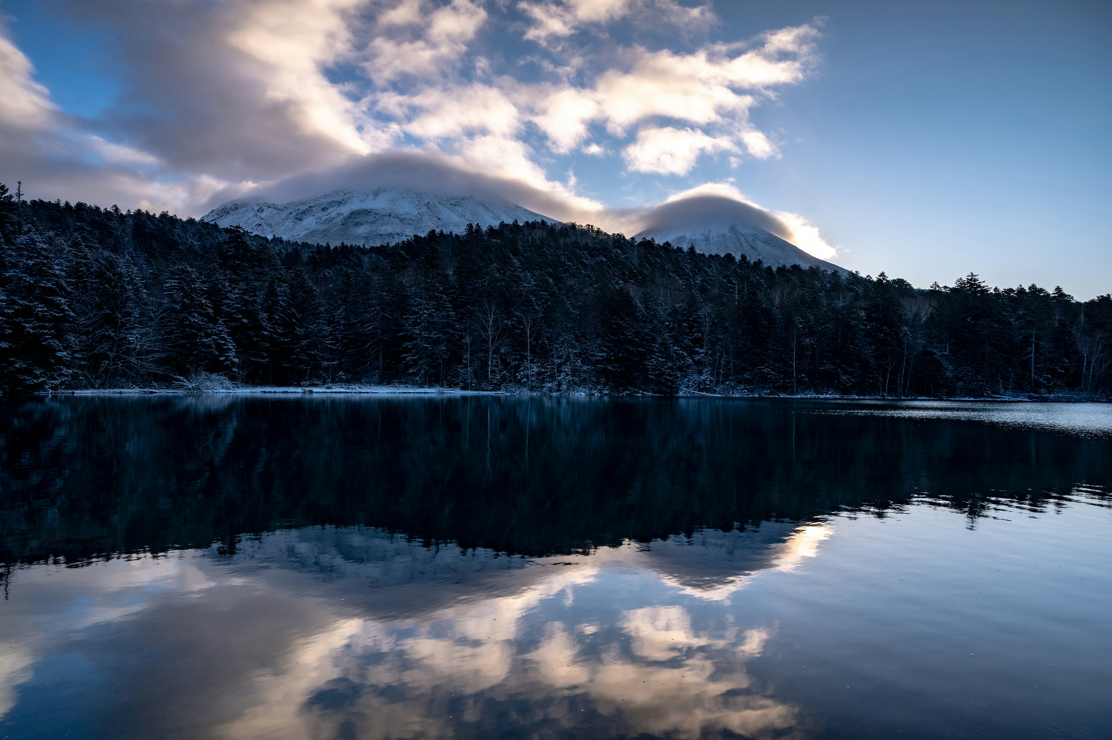 雪に覆われた山々と静かな湖の反映が美しい冬の風景