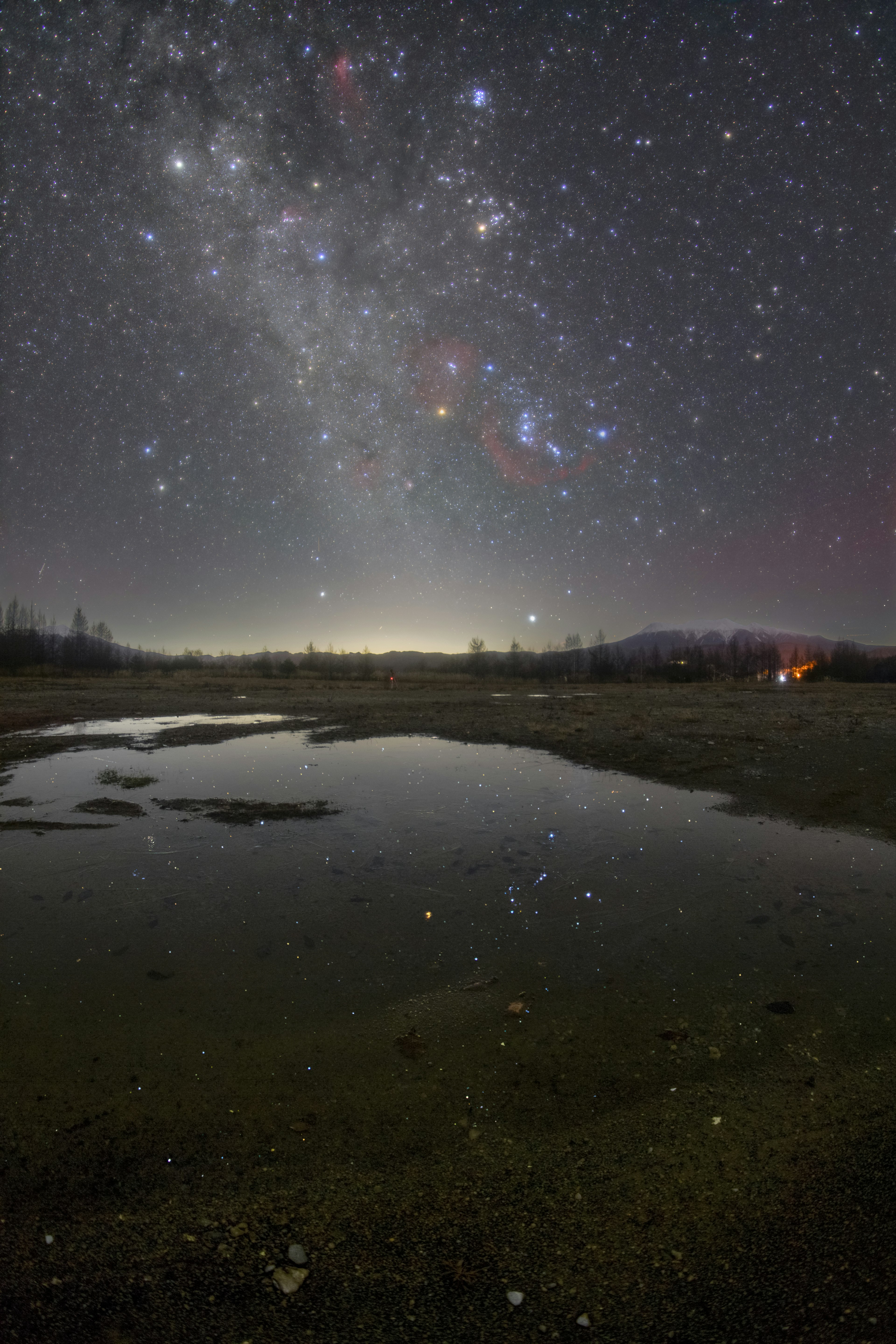 星空と水たまりが映る夜景の風景