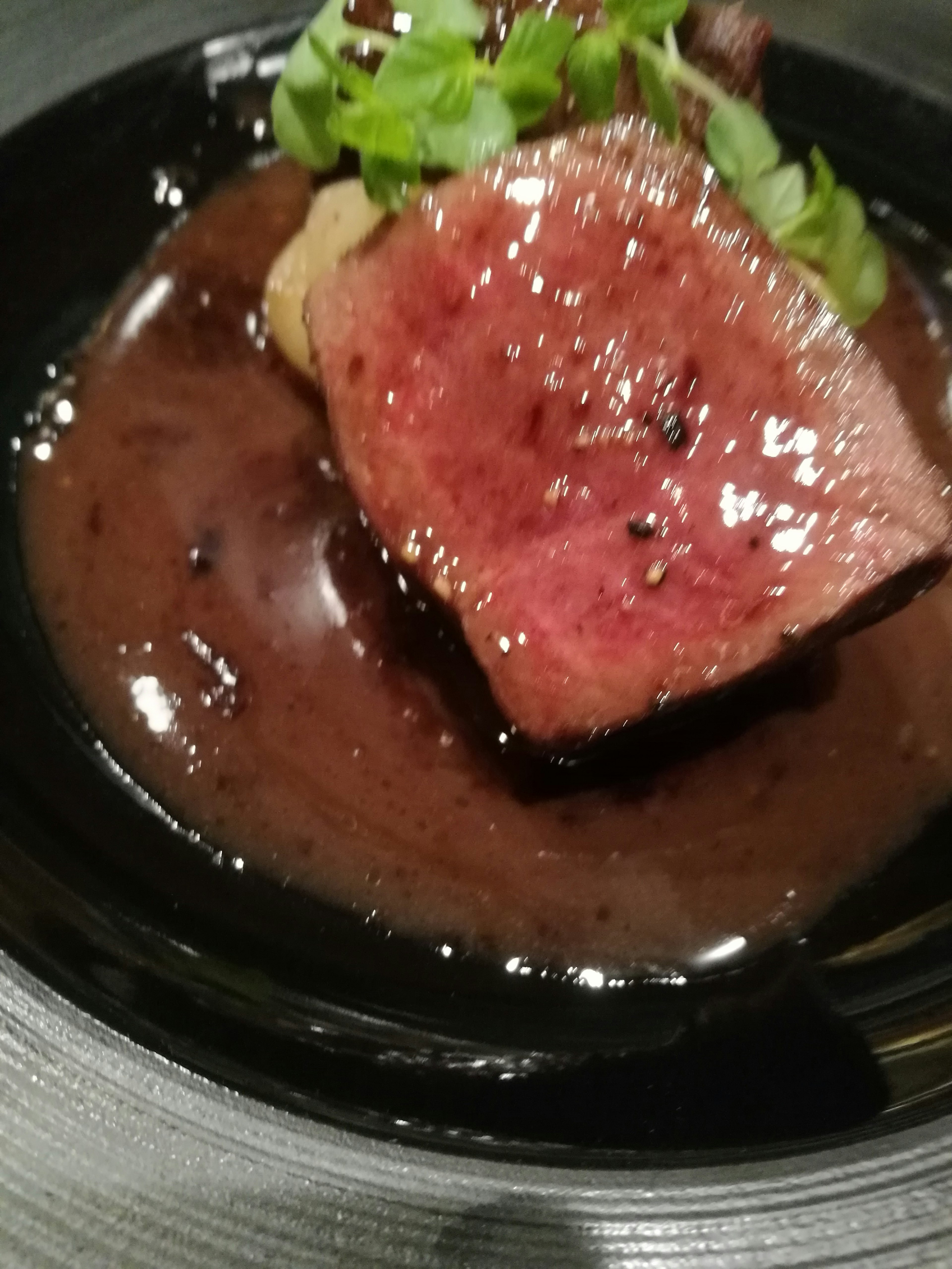 Succulento steak servito su una ricca salsa con erbe fresche