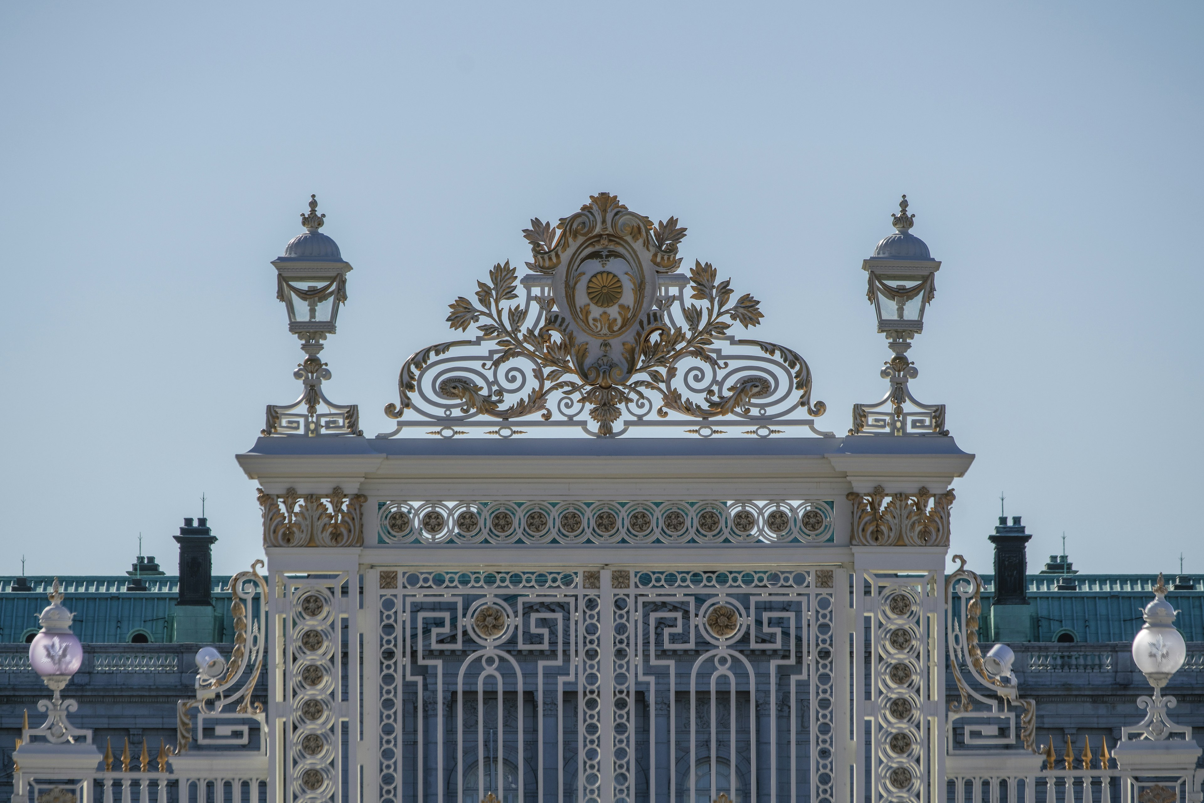 Parte superiore di un cancello ornato con lampade dorate e sculture intricate