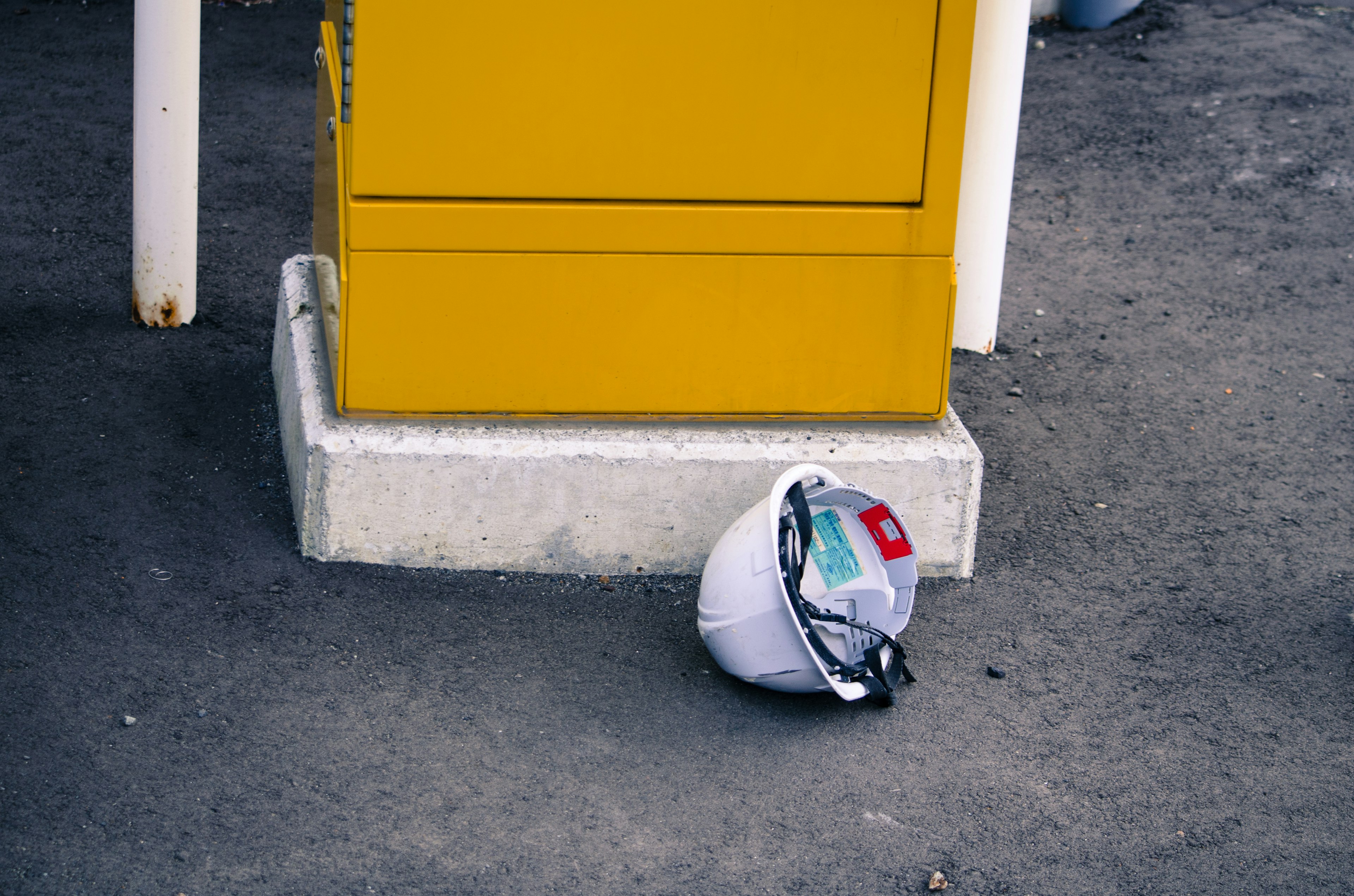 A white helmet placed near a yellow box