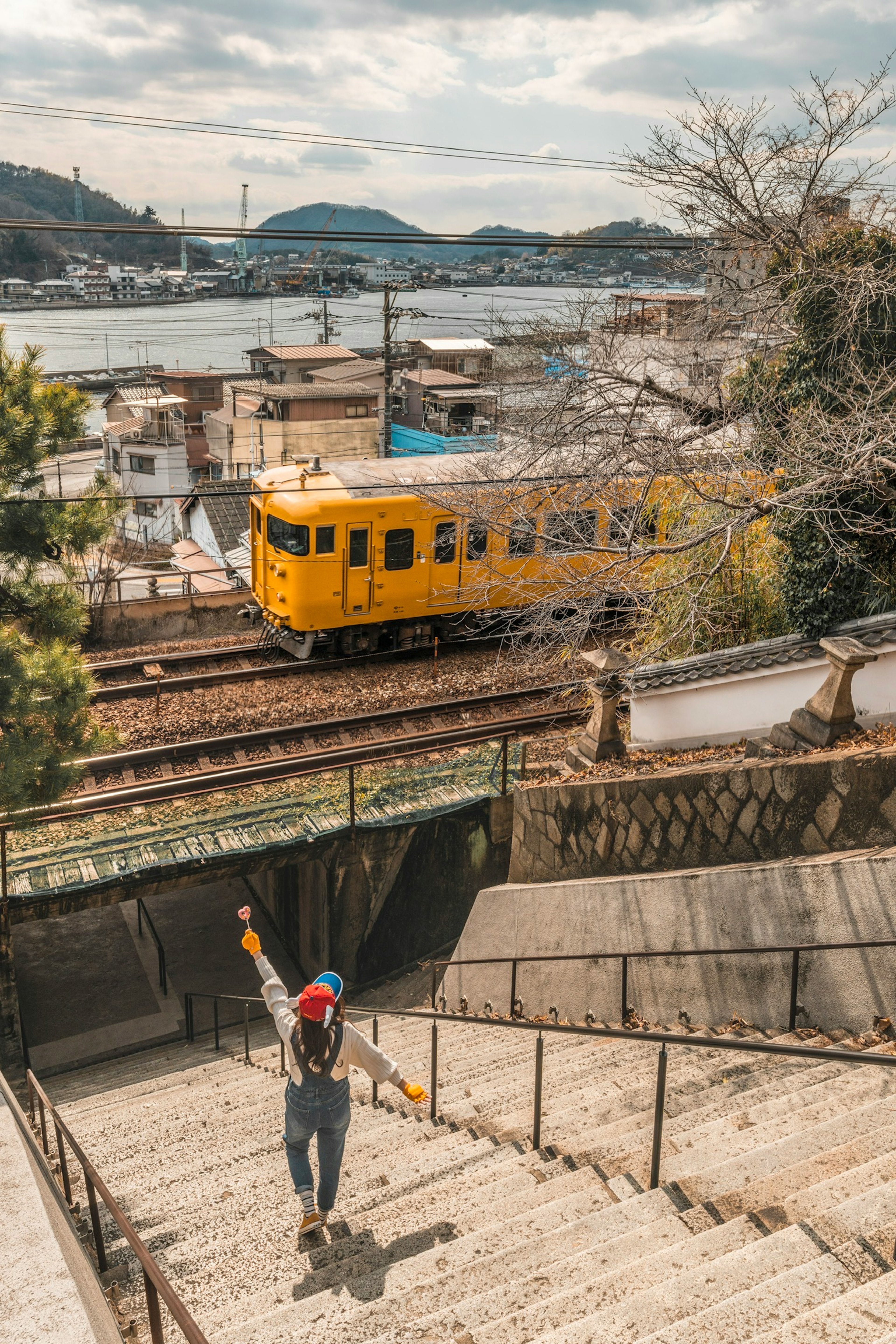 Eine Person, die Treppen hinuntergeht, mit einem gelben Zug im Hintergrund