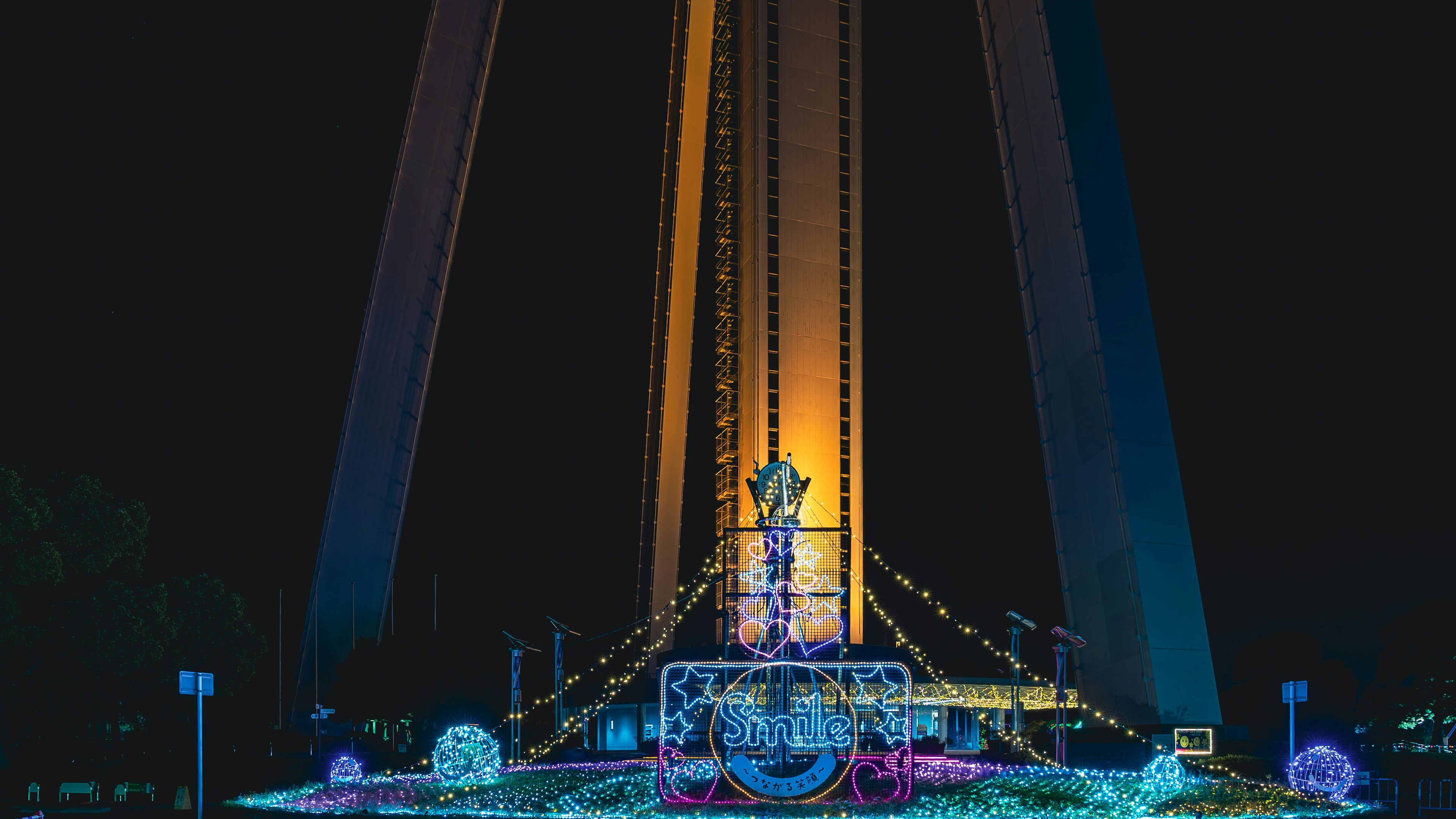 Objet illuminé sous un grand pont la nuit