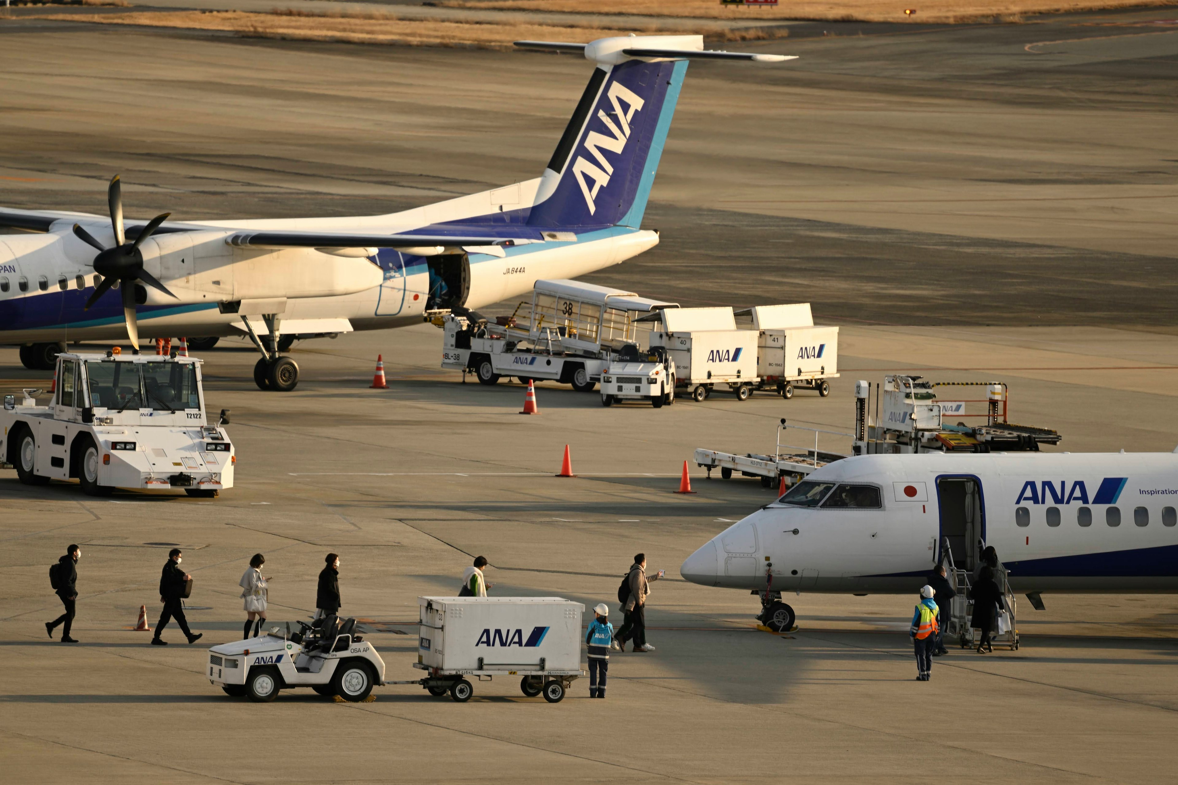 Passeggeri che salgono a bordo di un aereo ANA in aeroporto