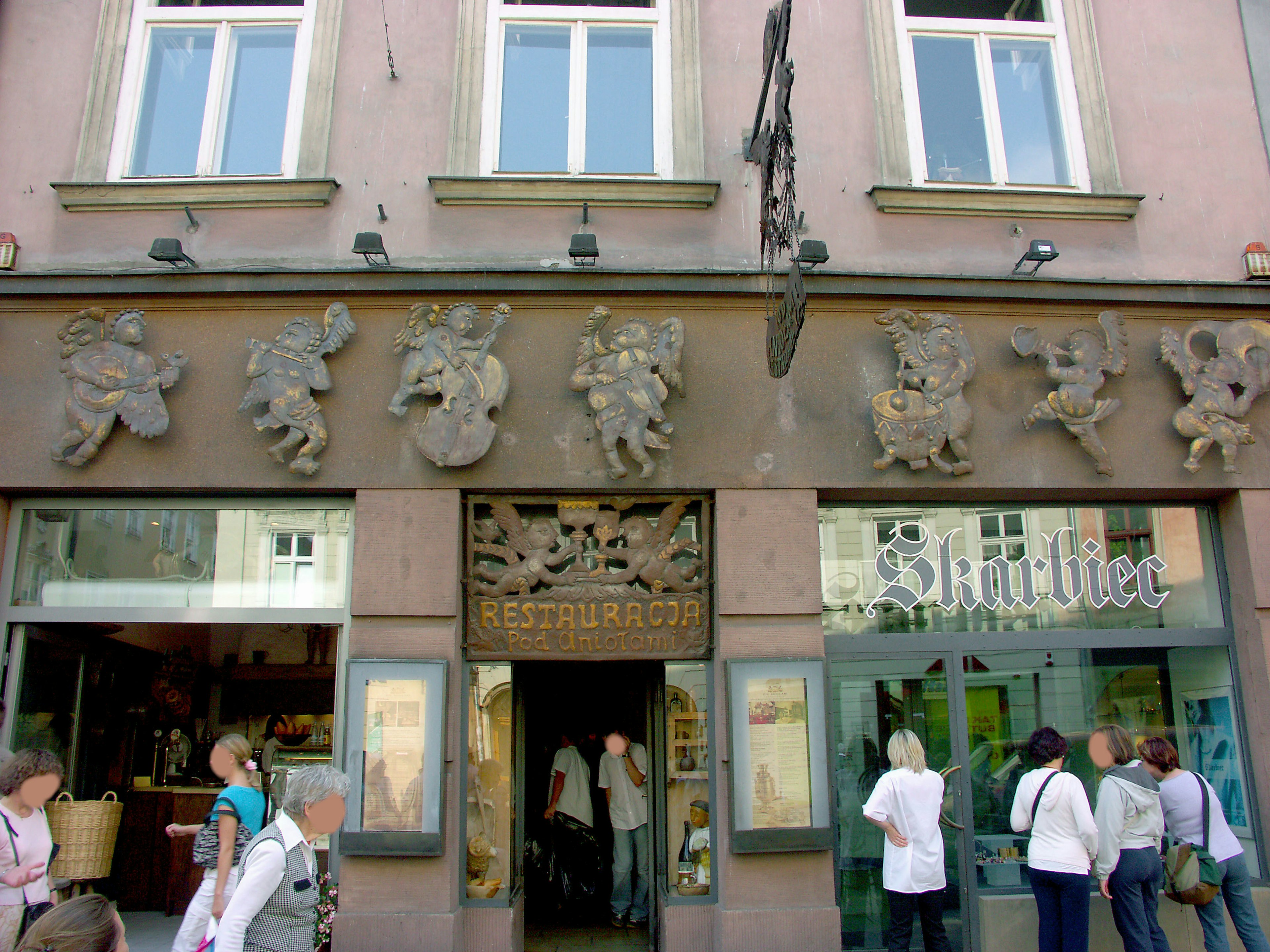 Fachada de un edificio histórico con esculturas decorativas y letrero