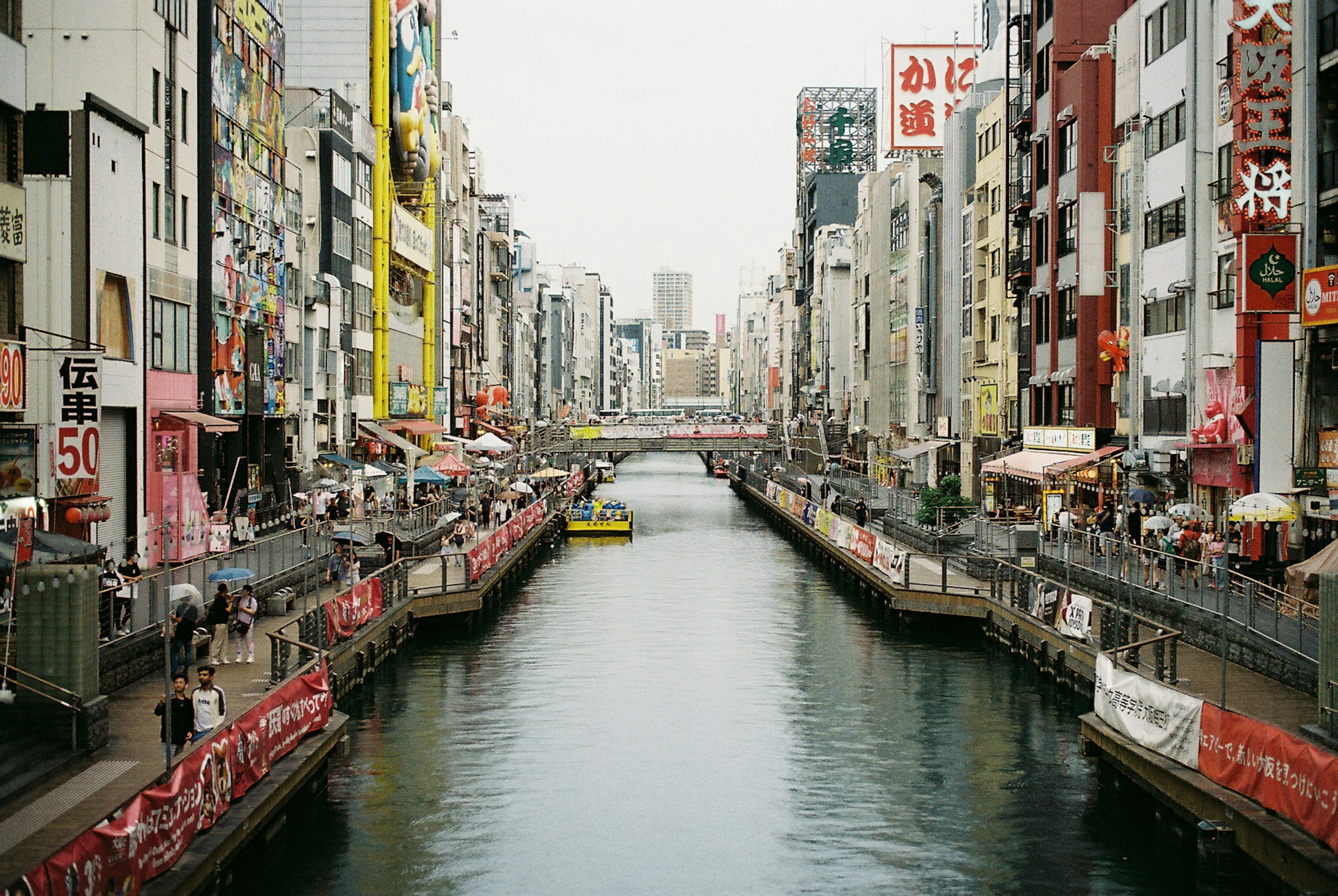 Vue d'un canal entouré de magasins colorés et d'enseignes