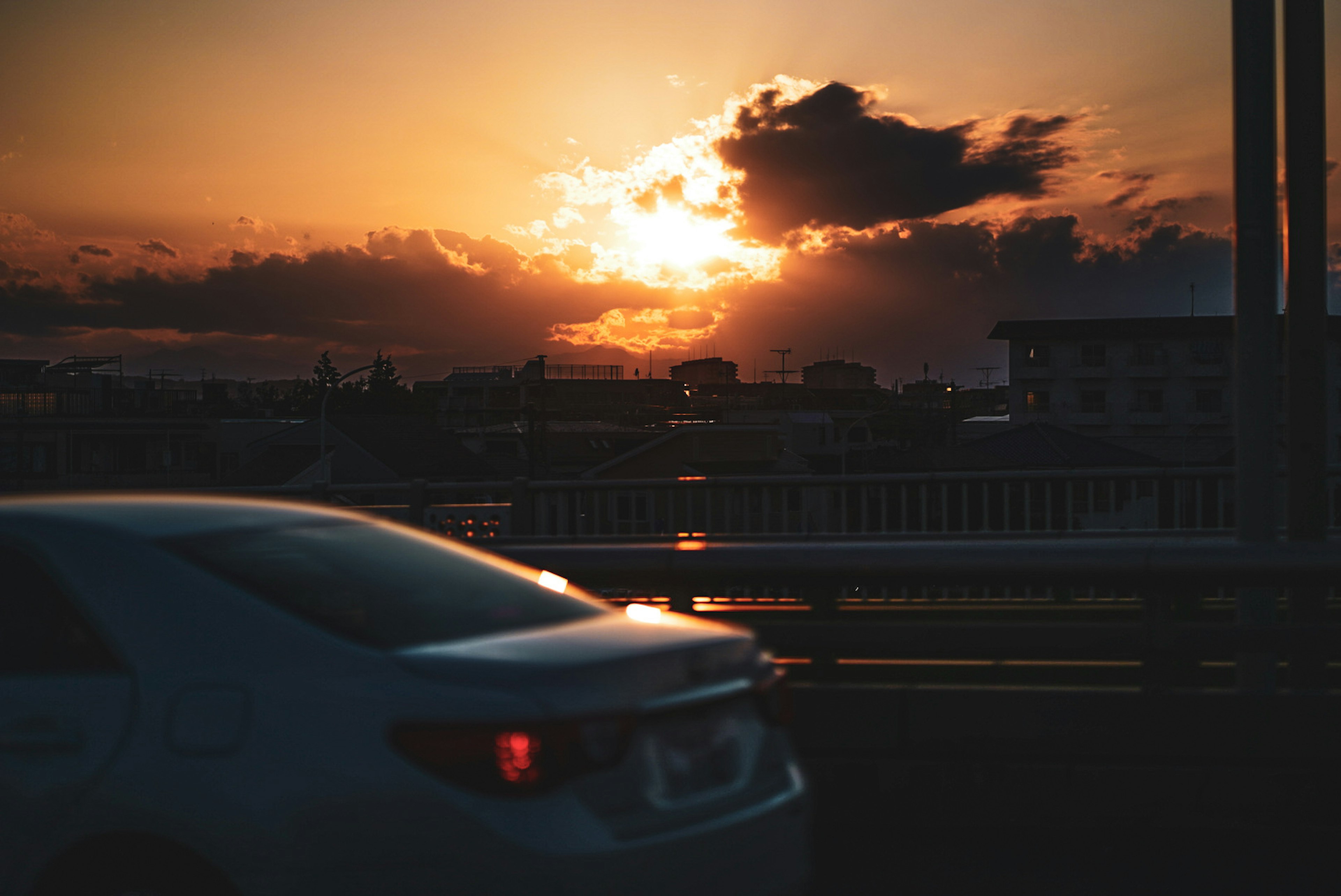 夕日が雲の間から差し込む風景 車が橋を走るシーン