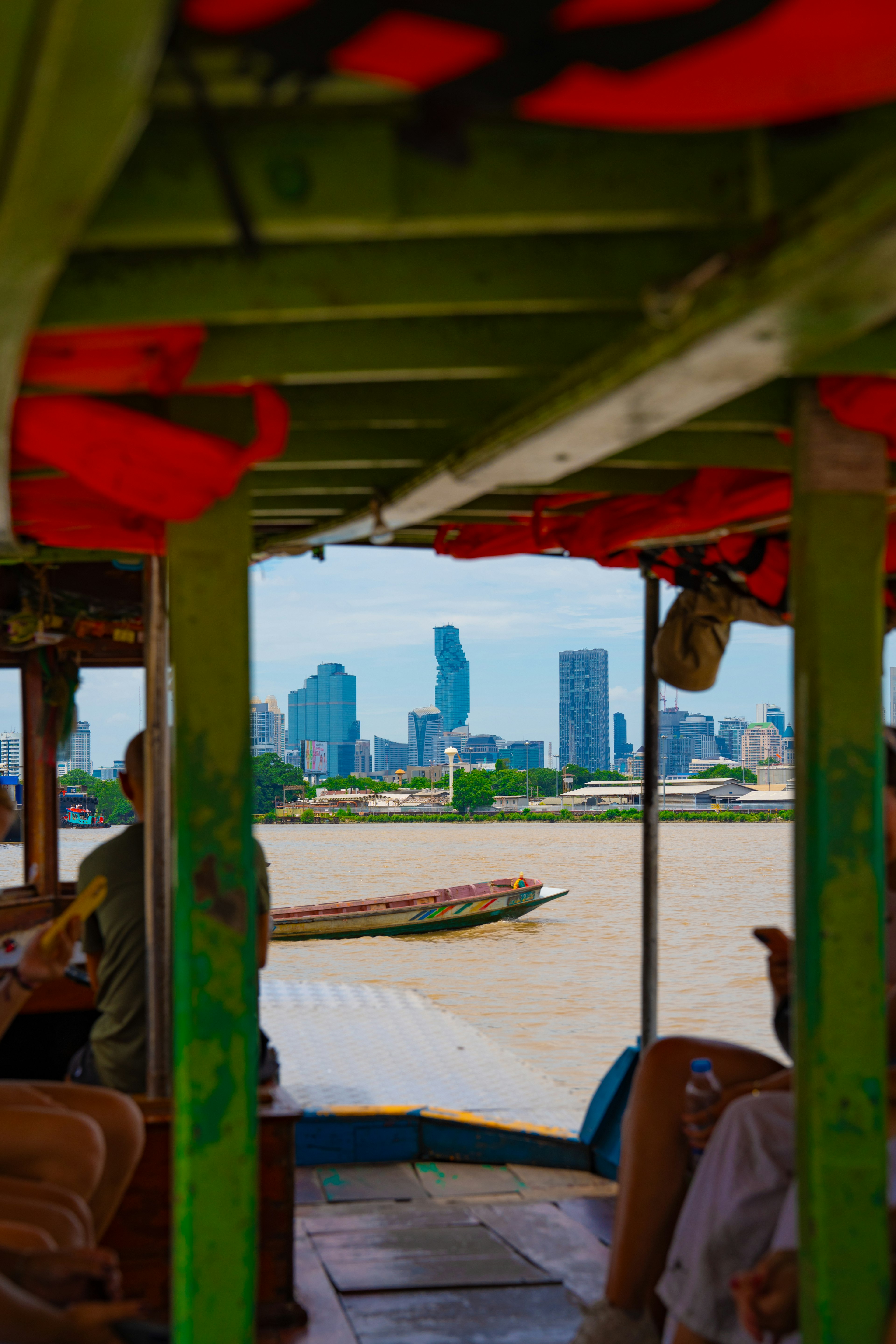 Vue d'une ligne d'horizon de la ville et d'une rivière depuis l'intérieur d'un bateau vert