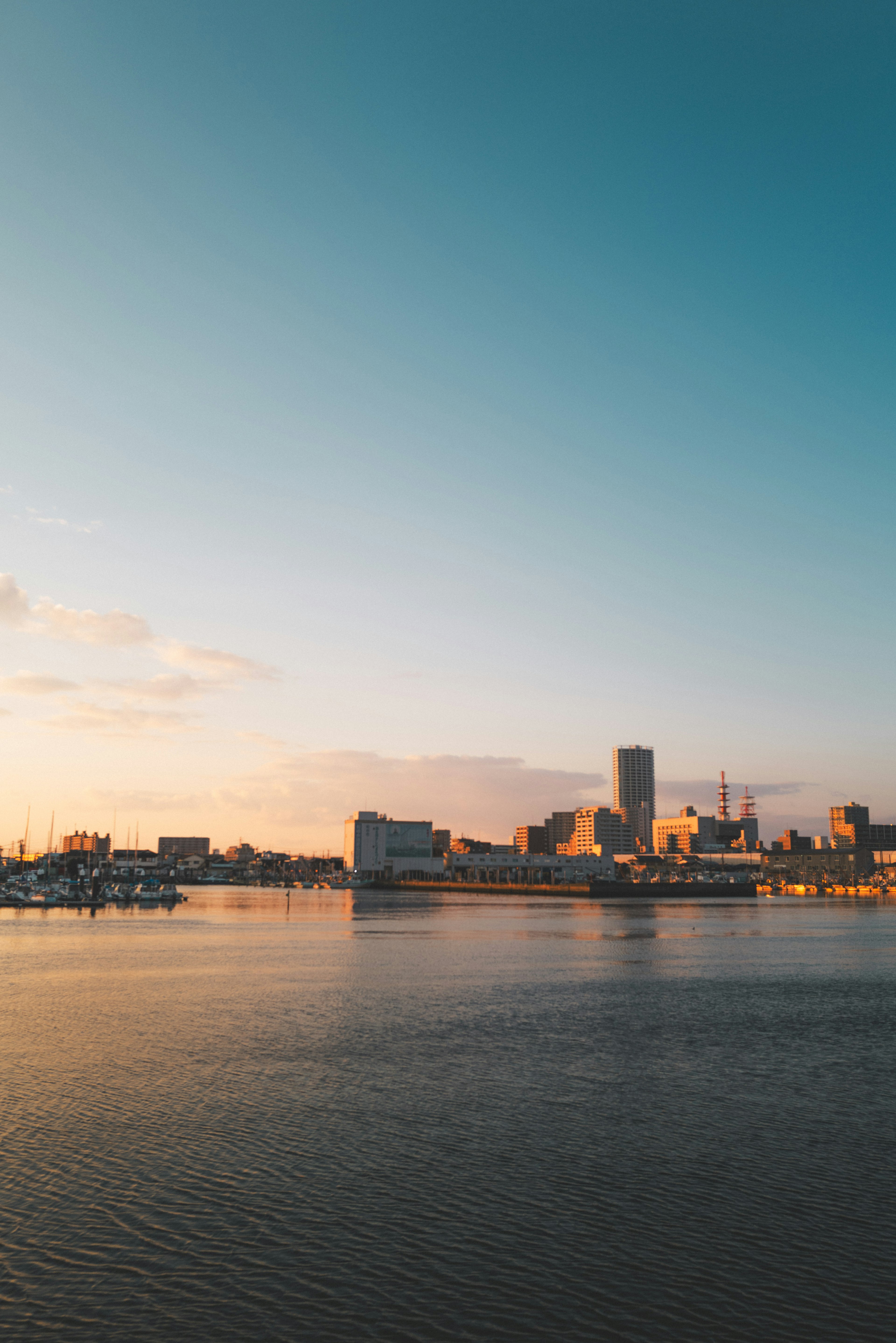 Hermoso paisaje de atardecer con el horizonte de la ciudad reflejado en el agua