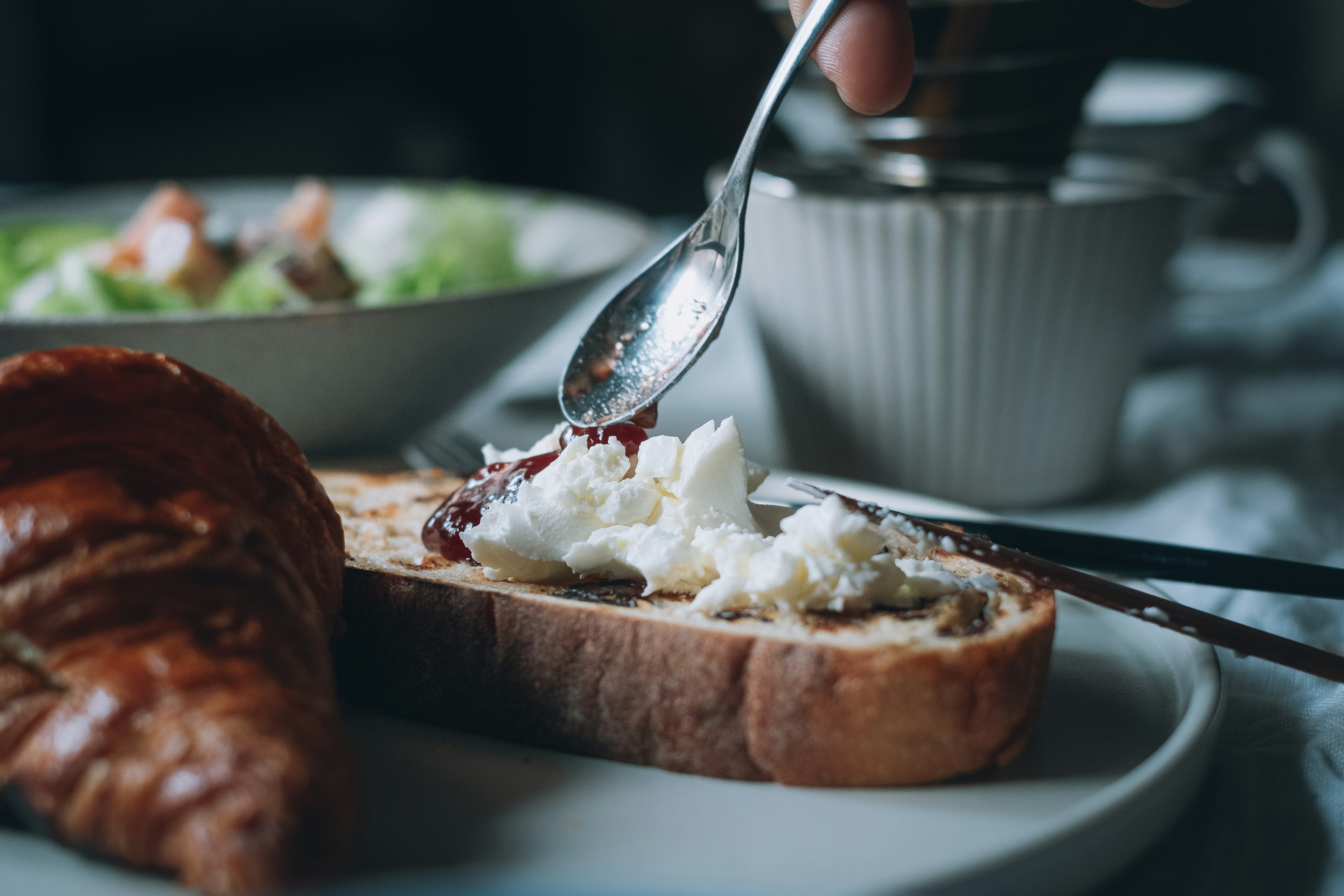 Piatto per colazione con toast guarnito di crema di formaggio e marmellata