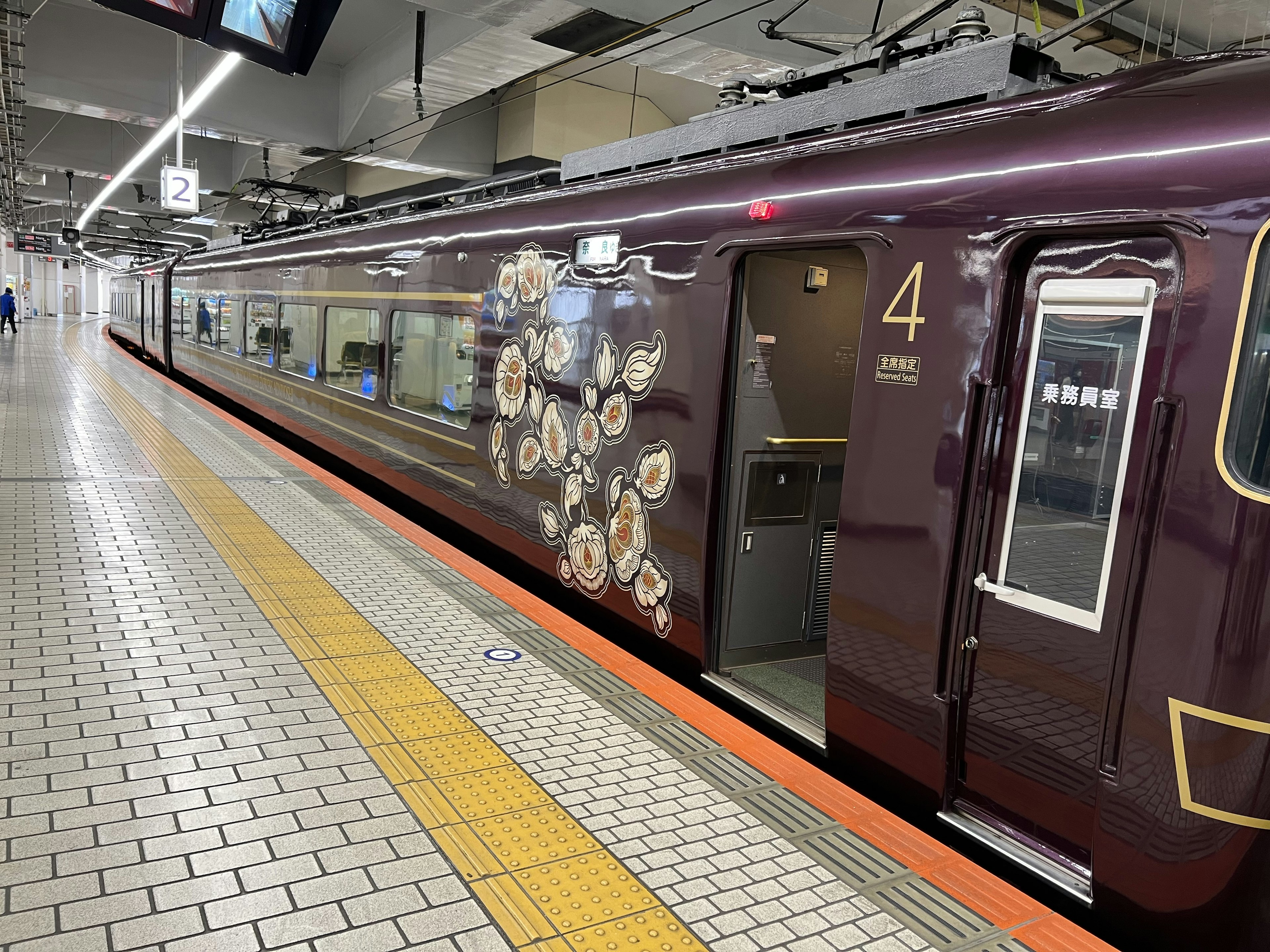 Purple train at a station platform featuring decorative elements and number 4