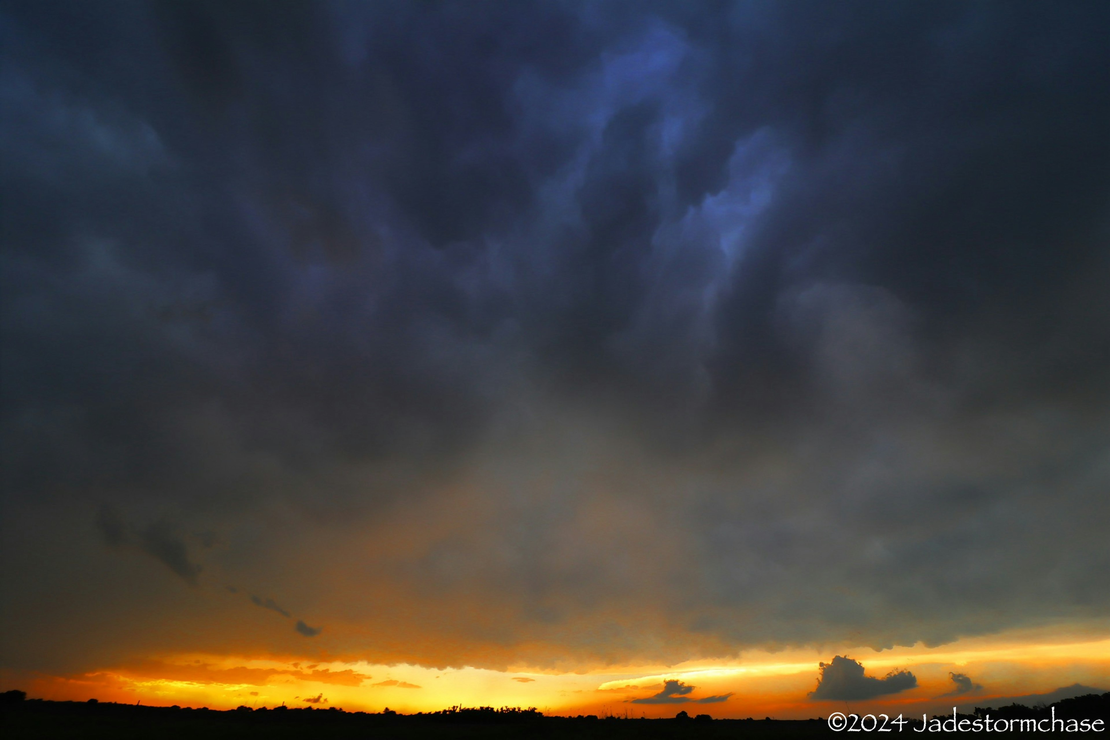 暗い雲に覆われた空とオレンジ色の夕焼け