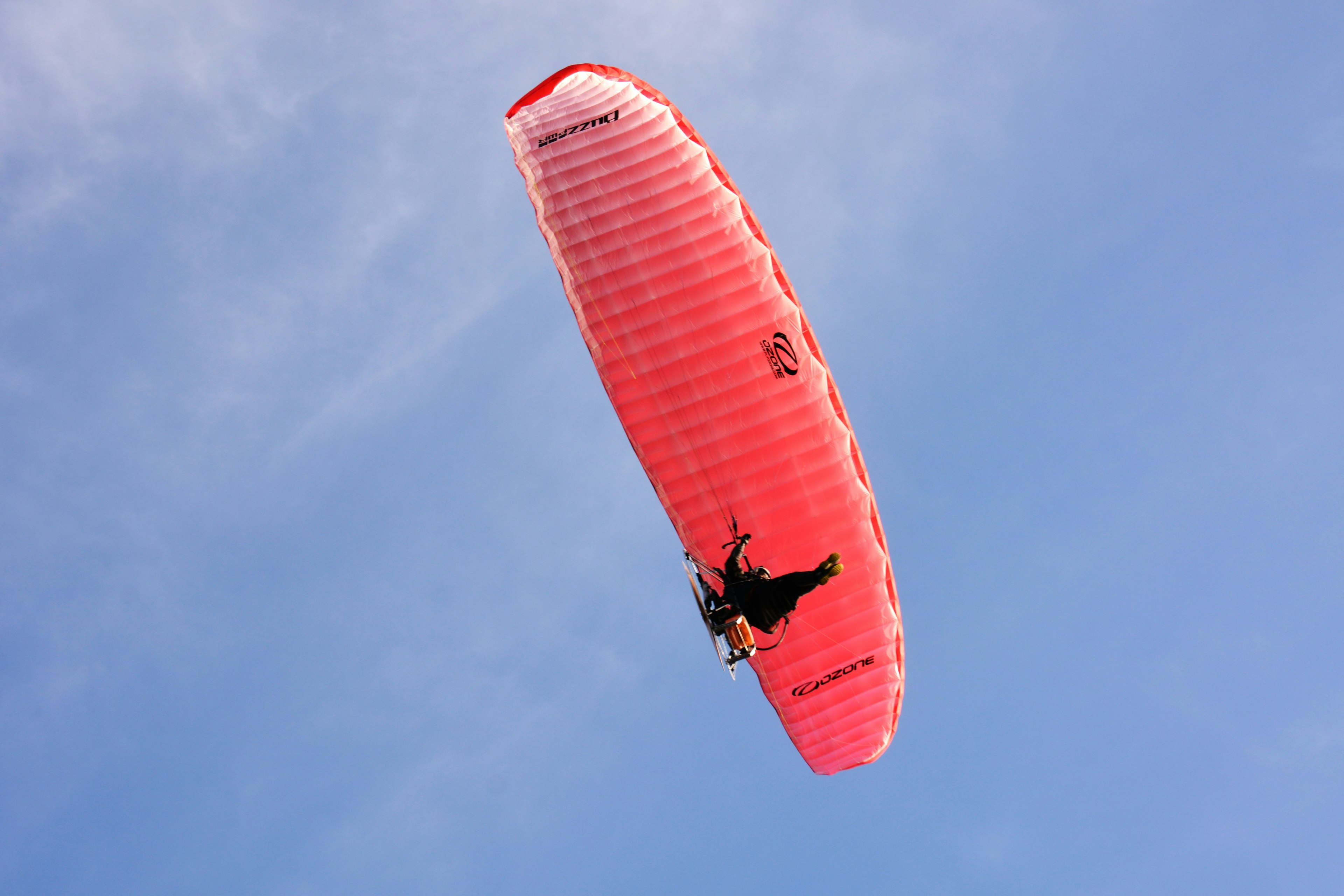 Un parapente rojo volando en el cielo