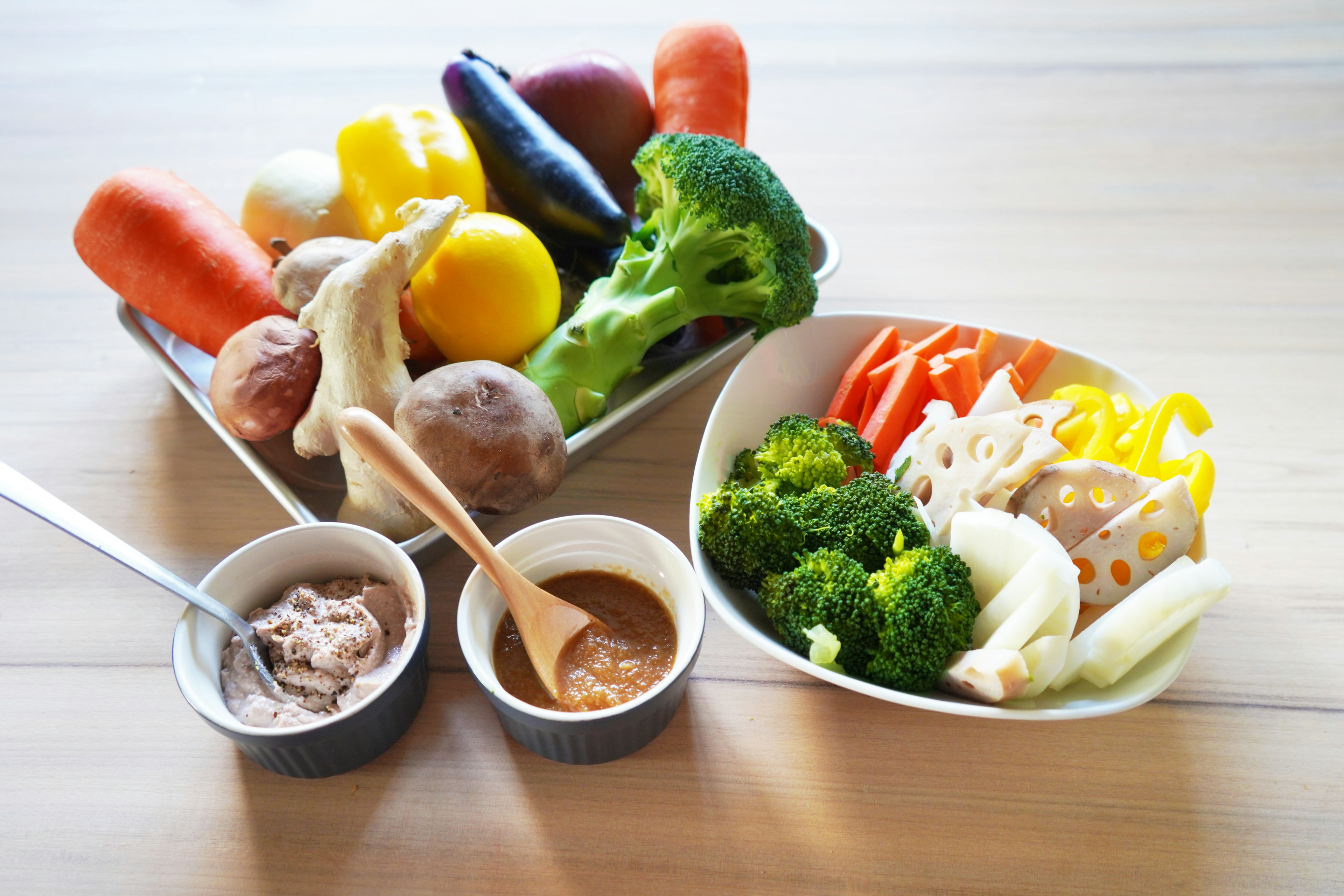 Colorful assortment of vegetables with dips on a wooden table