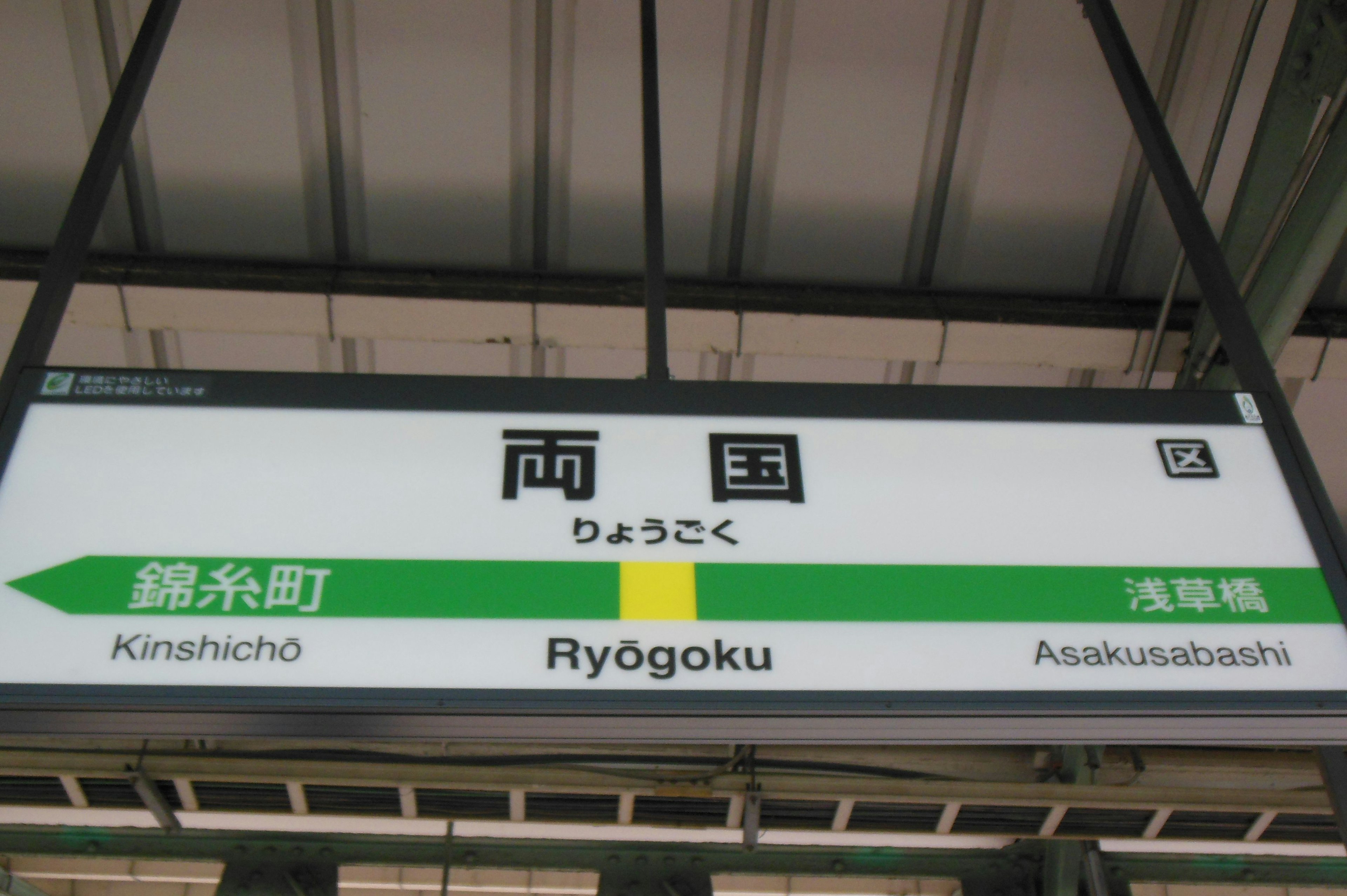 Ryogoku station sign featuring green arrows and text